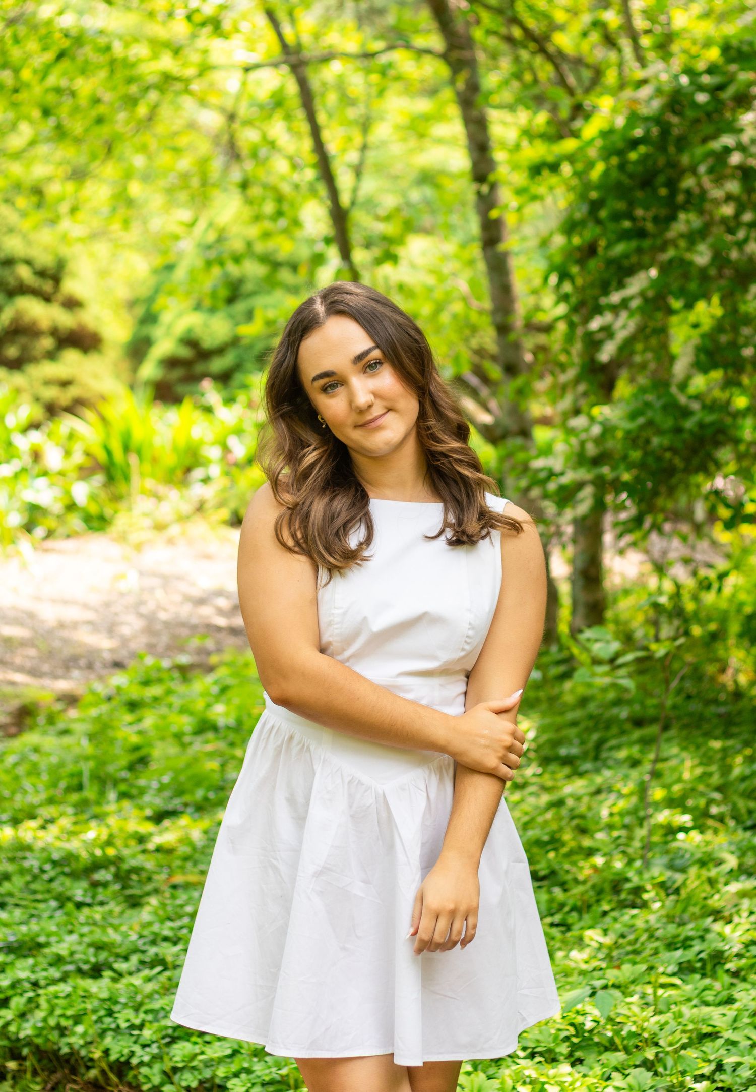 A white summer dress twirls in a lush green garden setting.