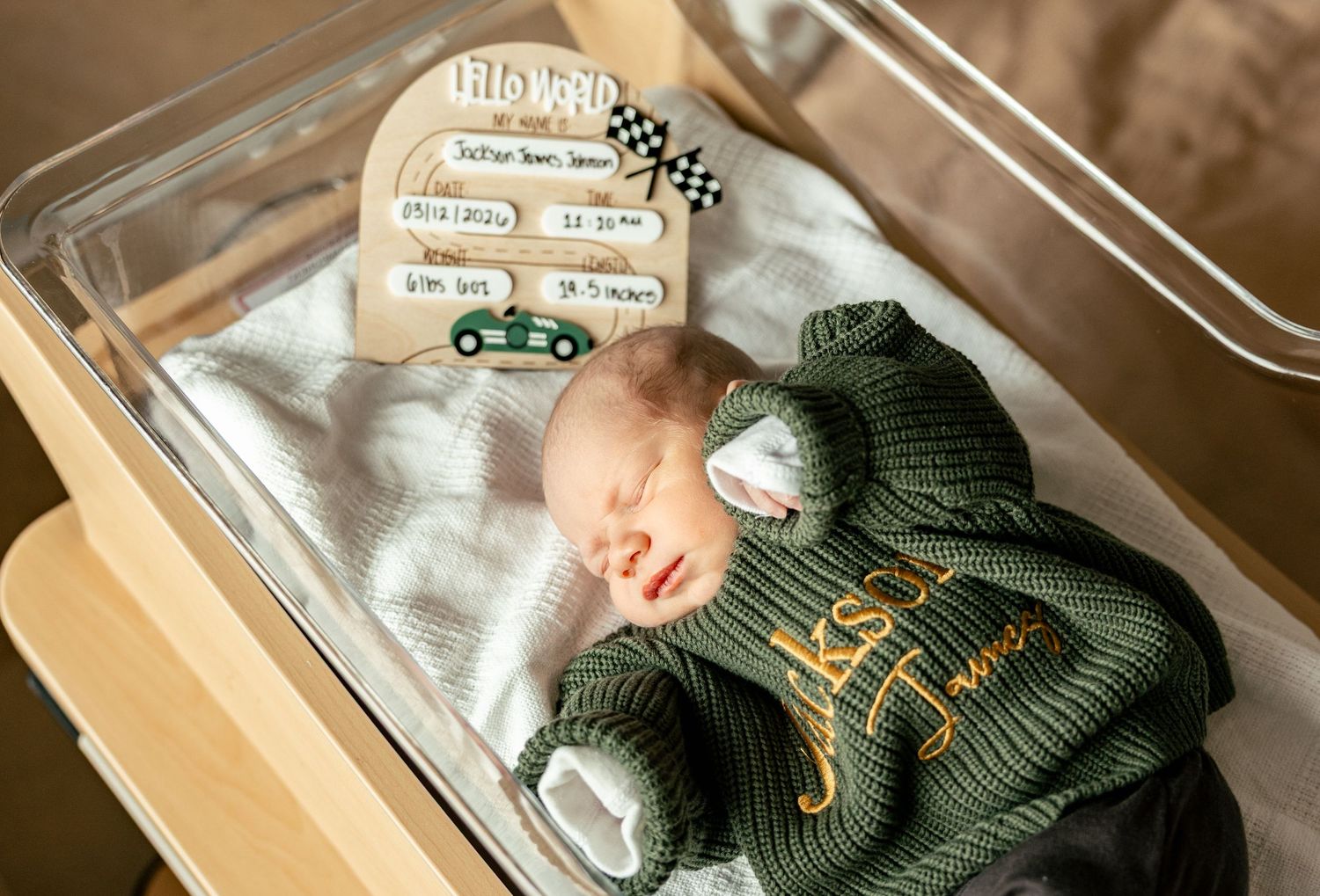 A collection of knitted green baby booties and mittens arranged in a gift box with delicate detailing.