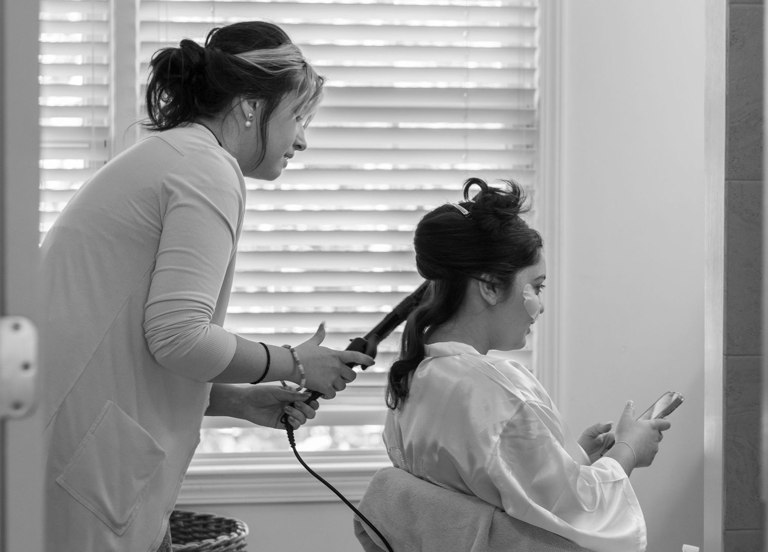 Wedding preparation scene with people getting ready in a bright room.