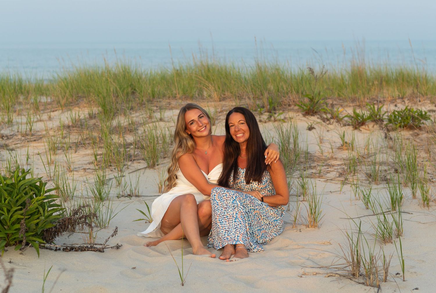 Candid beach photography session with sand dunes and ocean waves in the background.
