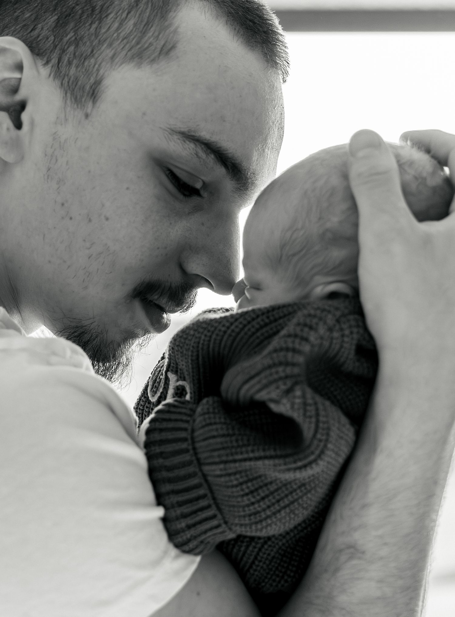 A series of four intimate black and white photos showing tender moments between two people in close embrace.
