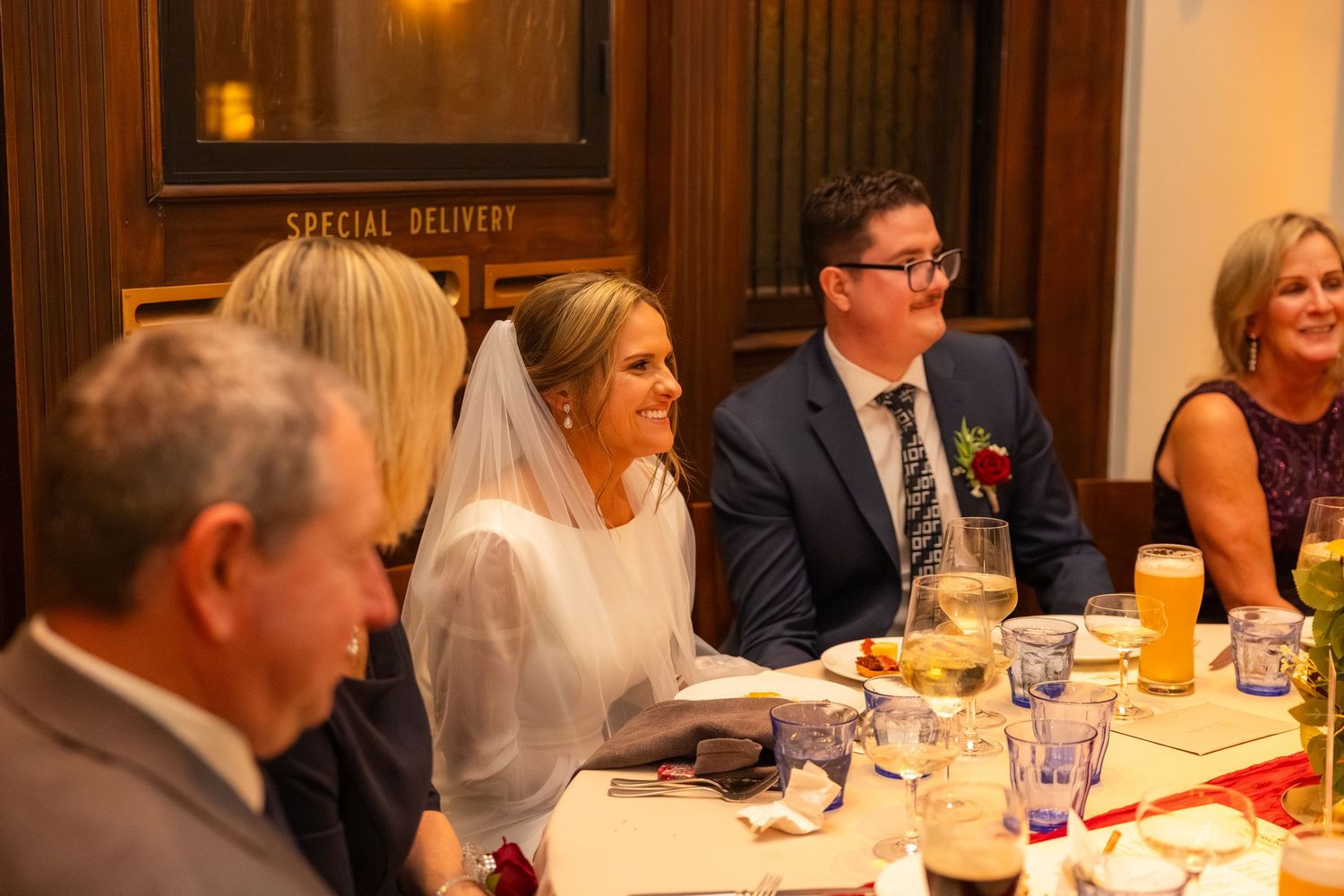Wedding reception dinner scene with guests seated at decorated tables.