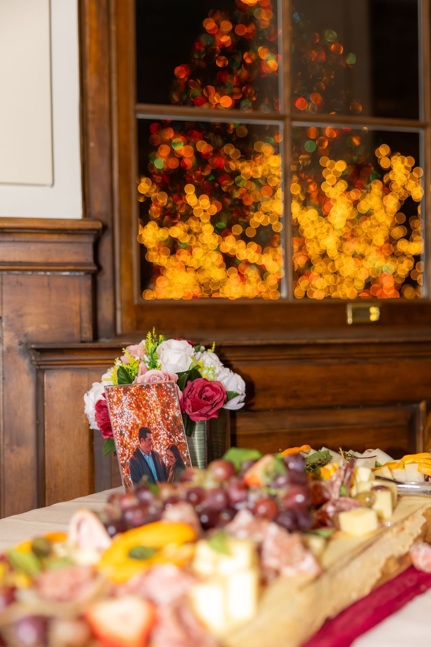 Elegant wedding reception table with floral arrangements and warm lighting through windows.