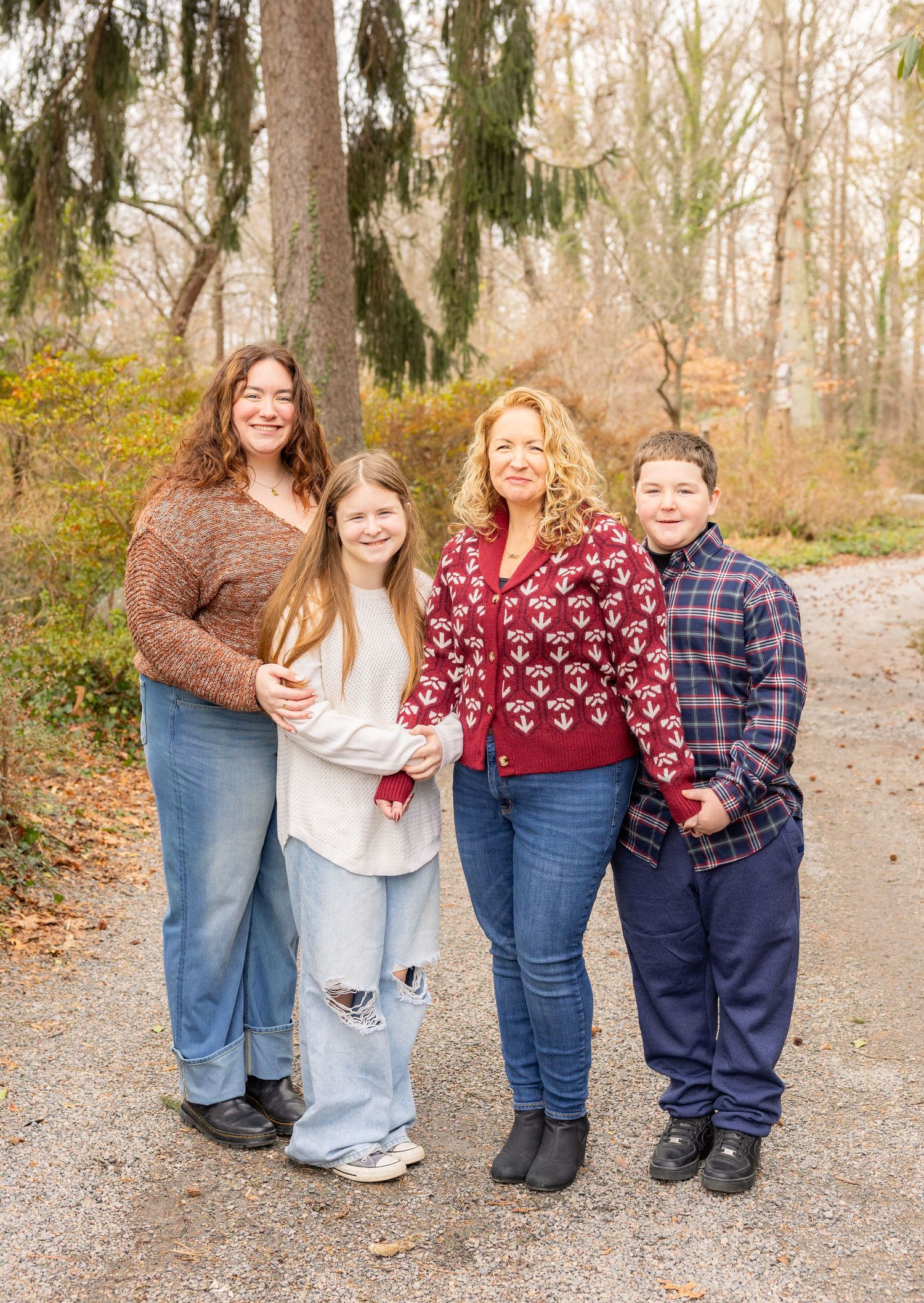 Family group photo showing legs and feet on a gravel path in autumn.