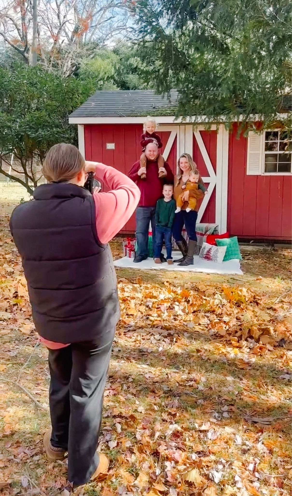 Photographer captures autumn scene with red cabin and fallen leaves in yard.