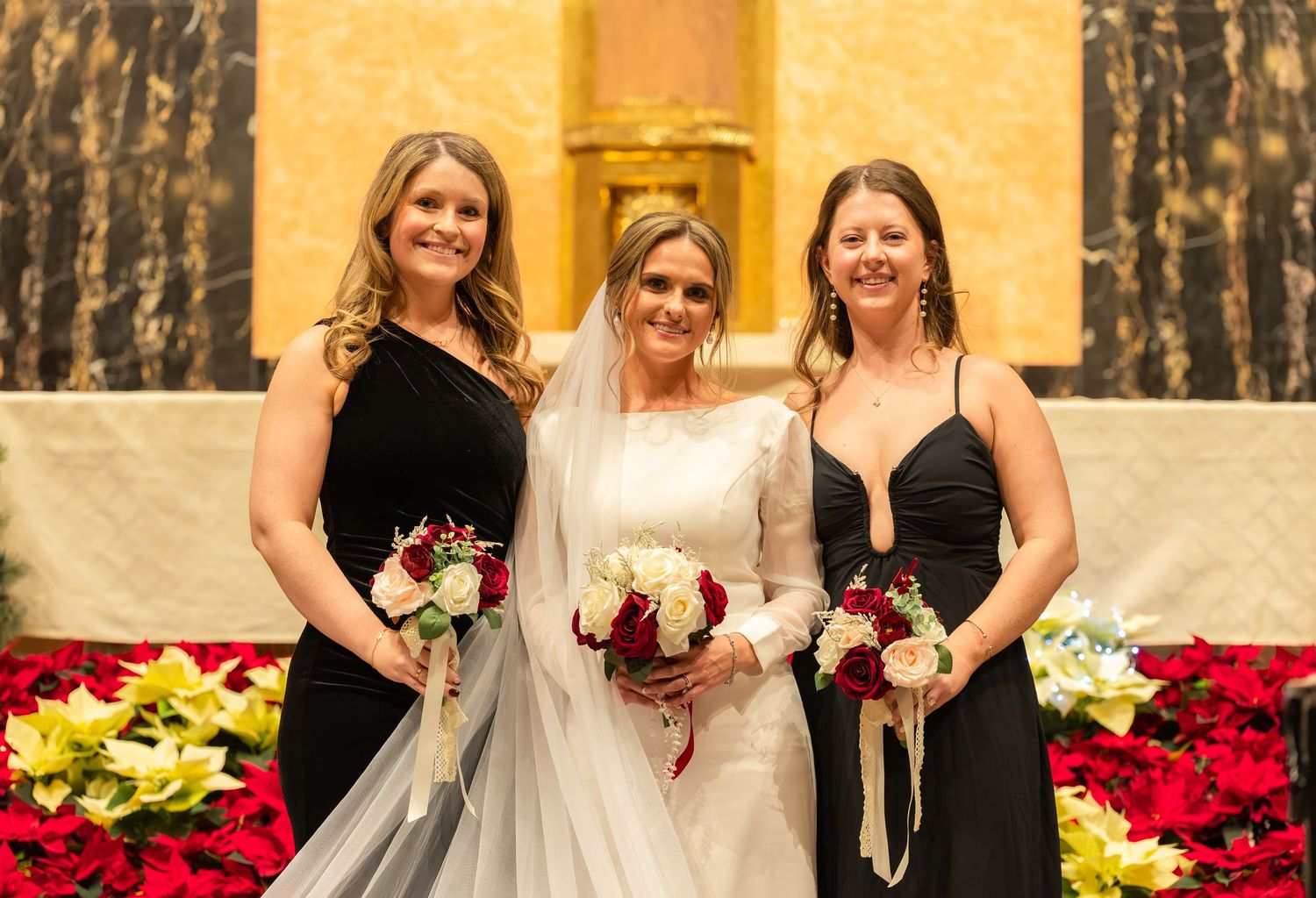 Wedding party gathered at altar with poinsettias and Christmas decorations in church setting.
