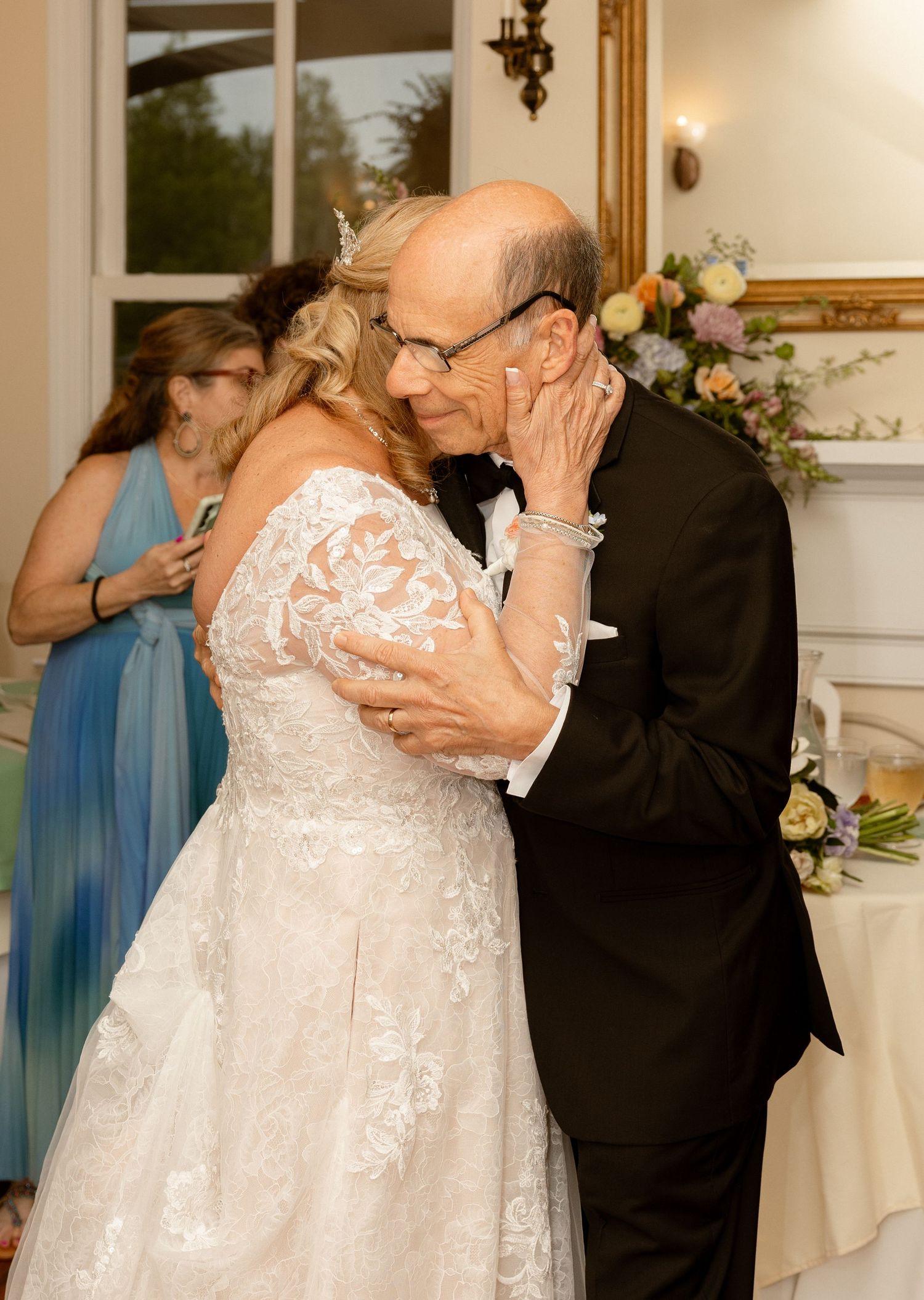 Elderly couple sharing a tender first dance at their wedding reception, bride in lace gown, groom in tuxedo.
