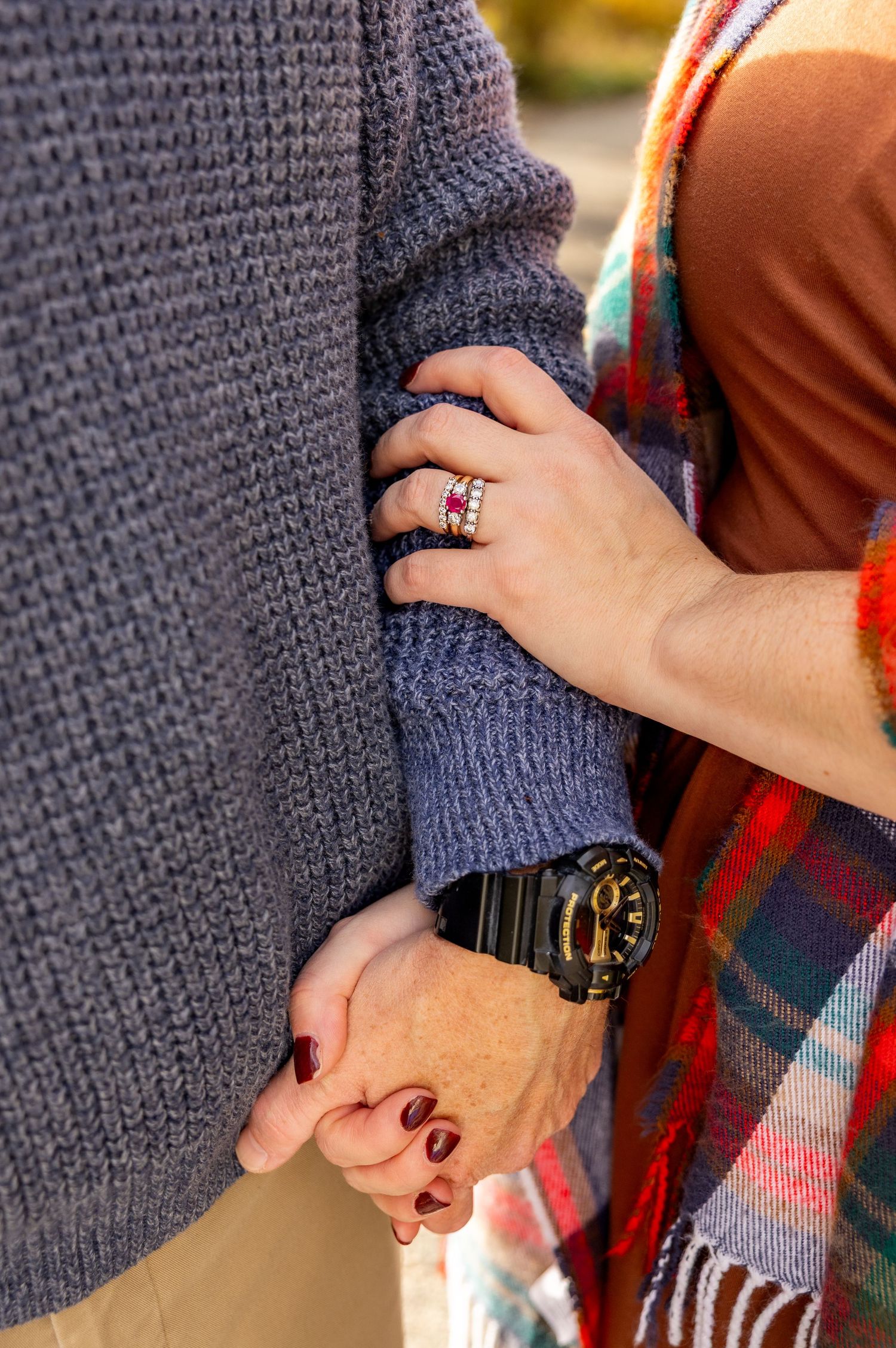 Close-up detail shots of hands holding a gray knit sweater and plaid blanket.