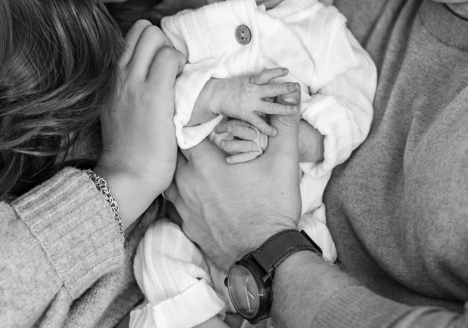 Black and white portrait of intimate family moment with newborn baby.
