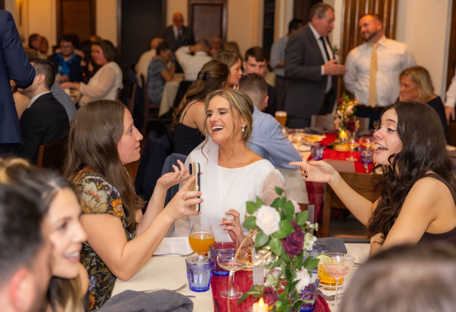 Guests gathered at elegantly decorated tables during an indoor wedding reception.