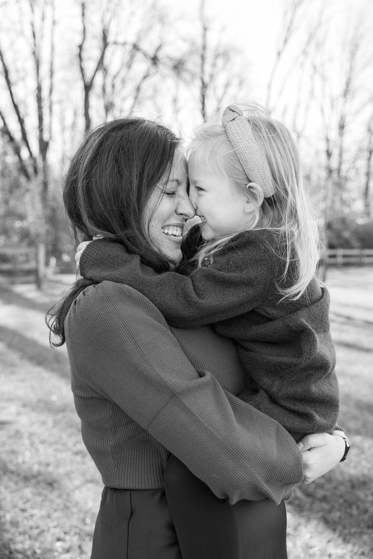 Candid black and white photos showing mom and daughter embracing and laughing outdoors.