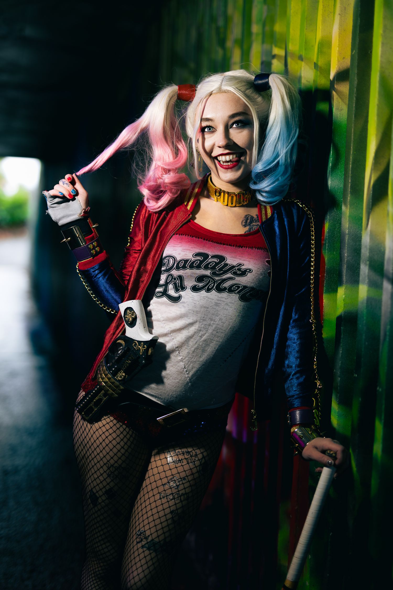 Cosplay photoshoot featuring a character in red and blue outfit against a graffiti wall.