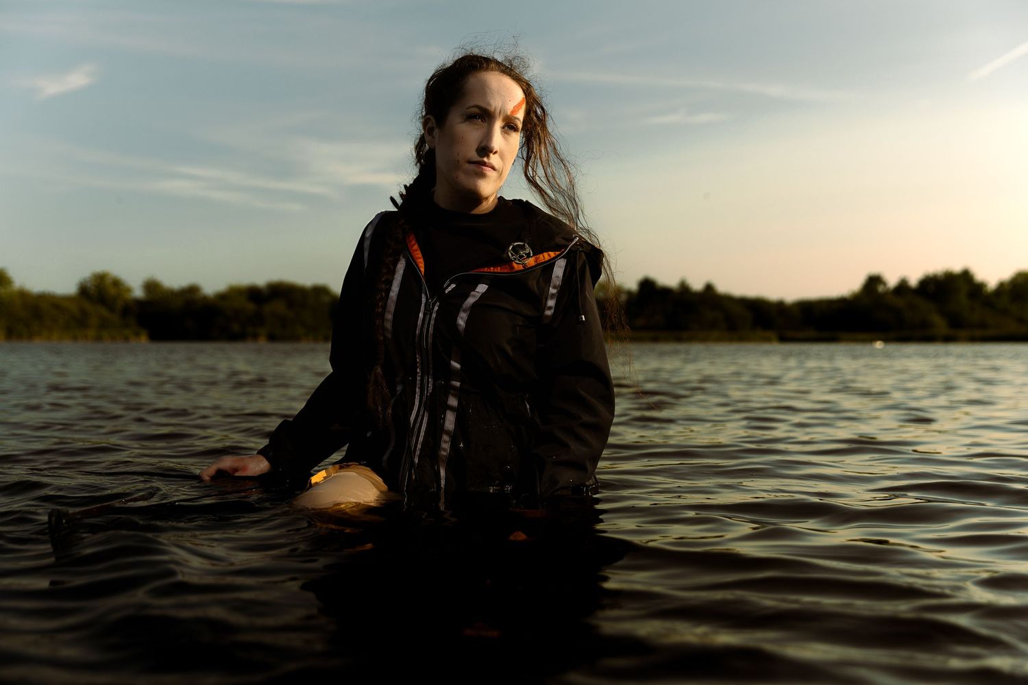 Moody portrait of cosplayer in water during sunset.
