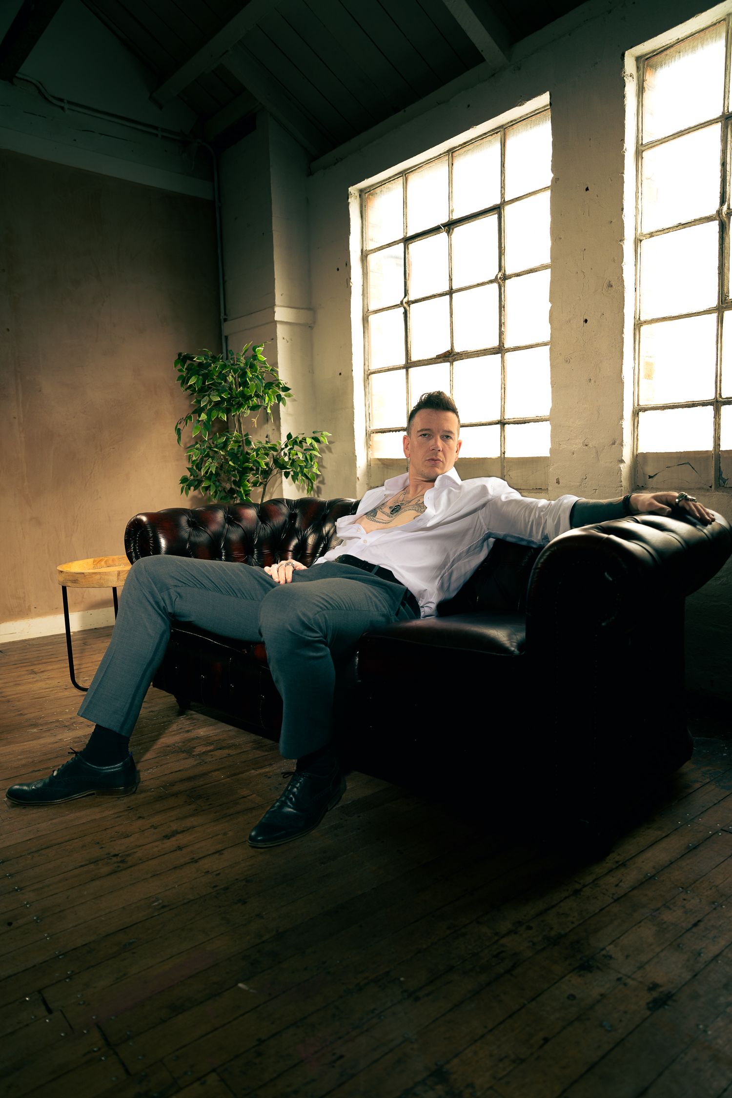 Dramatic portrait series in an industrial space with natural window lighting.