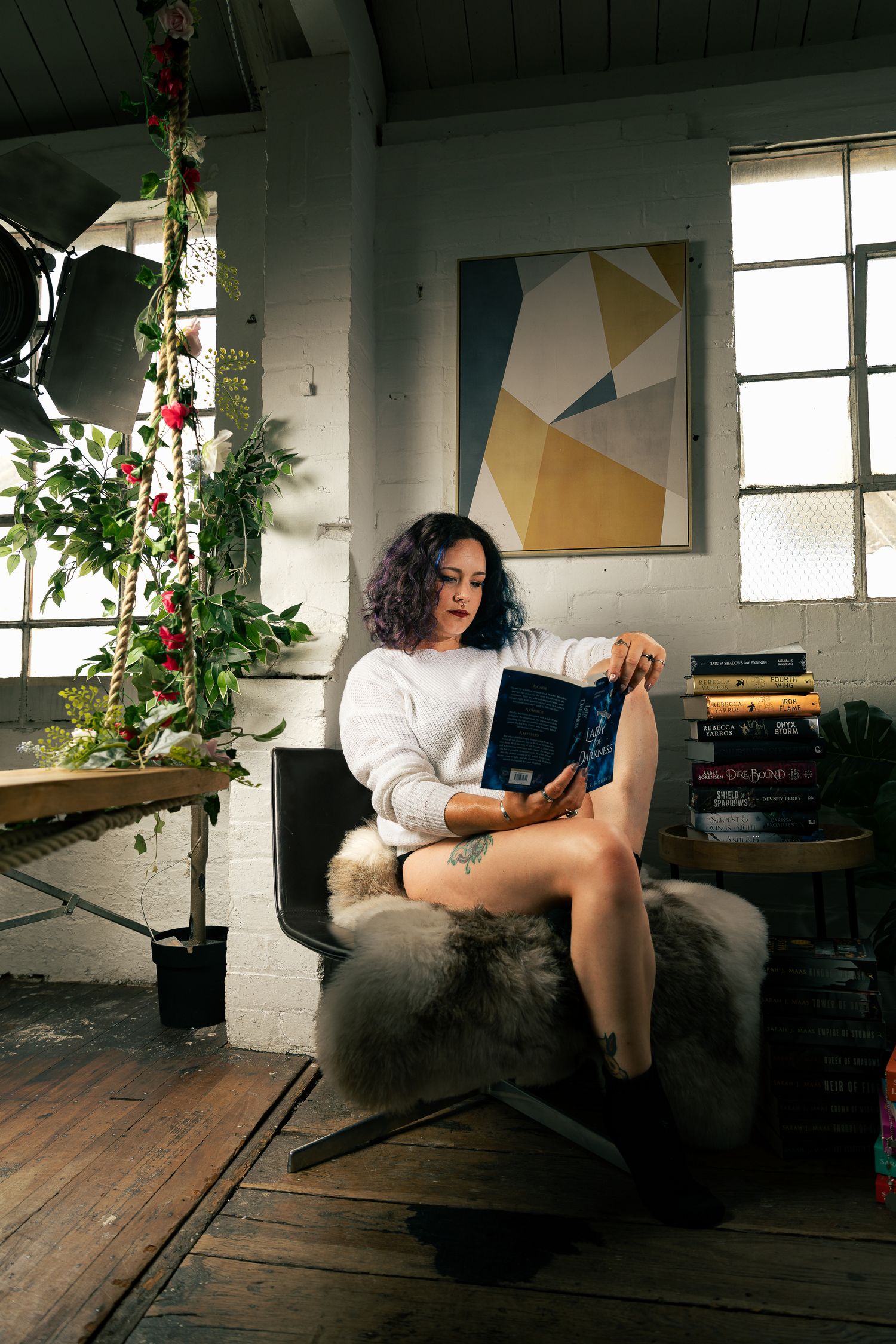 Cozy reading scene in industrial loft space with plants and books.