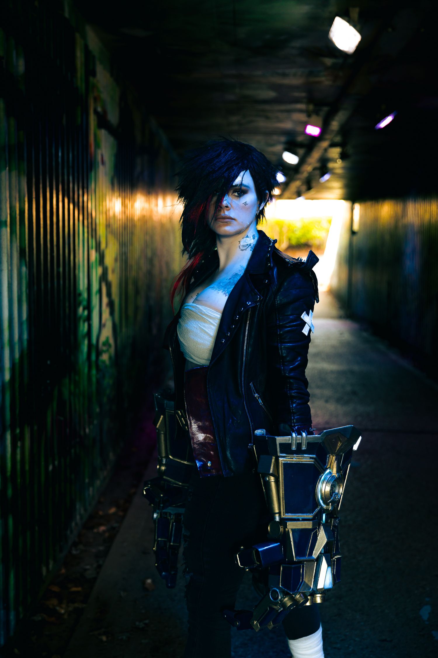 Moody nighttime photoshoot in an urban alley with dramatic lighting and dark atmosphere.