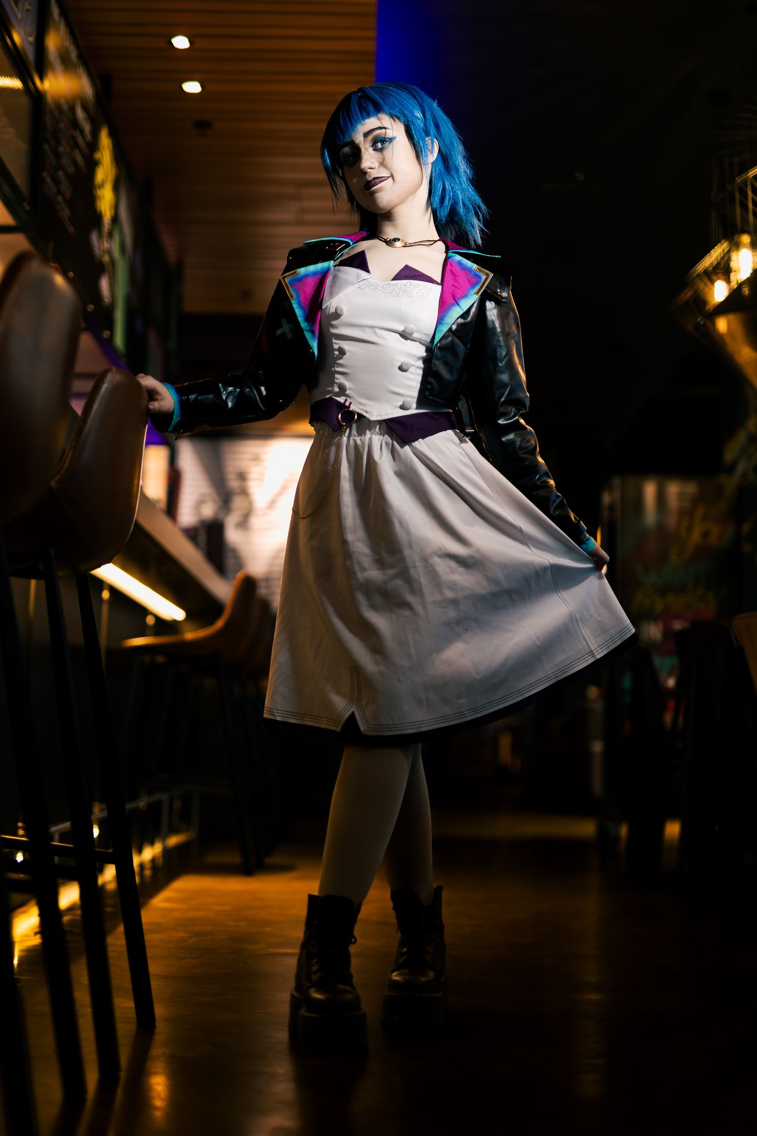 Stylized costume photography with dramatic lighting in a dark indoor setting.