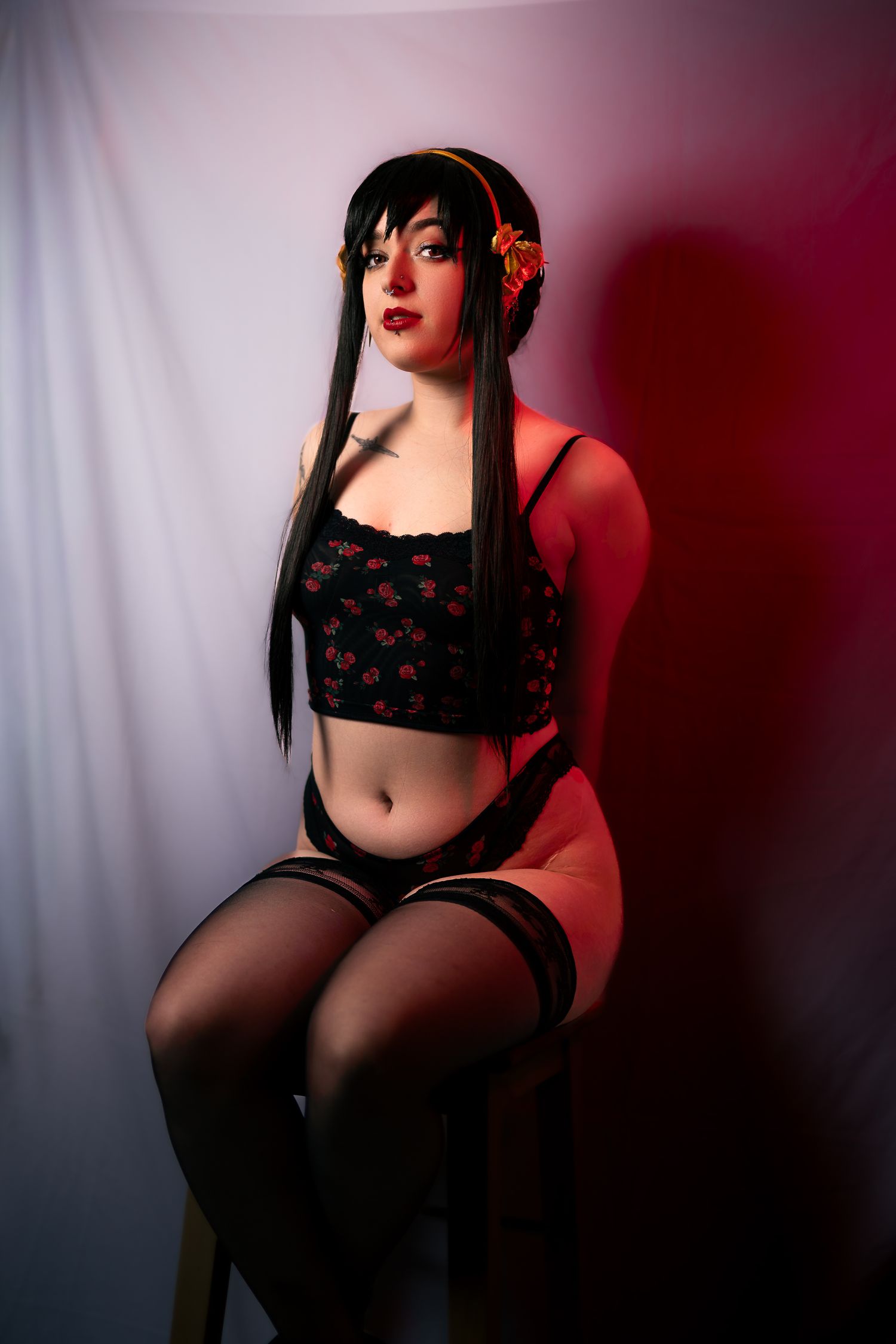 Moody boudoir photography with black lace lingerie in red and blue lighting.