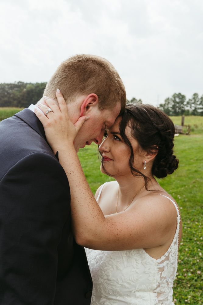 Emotional bride and groom portrait during an August outdoor wedding in New Boston, Michigan in a grassy field