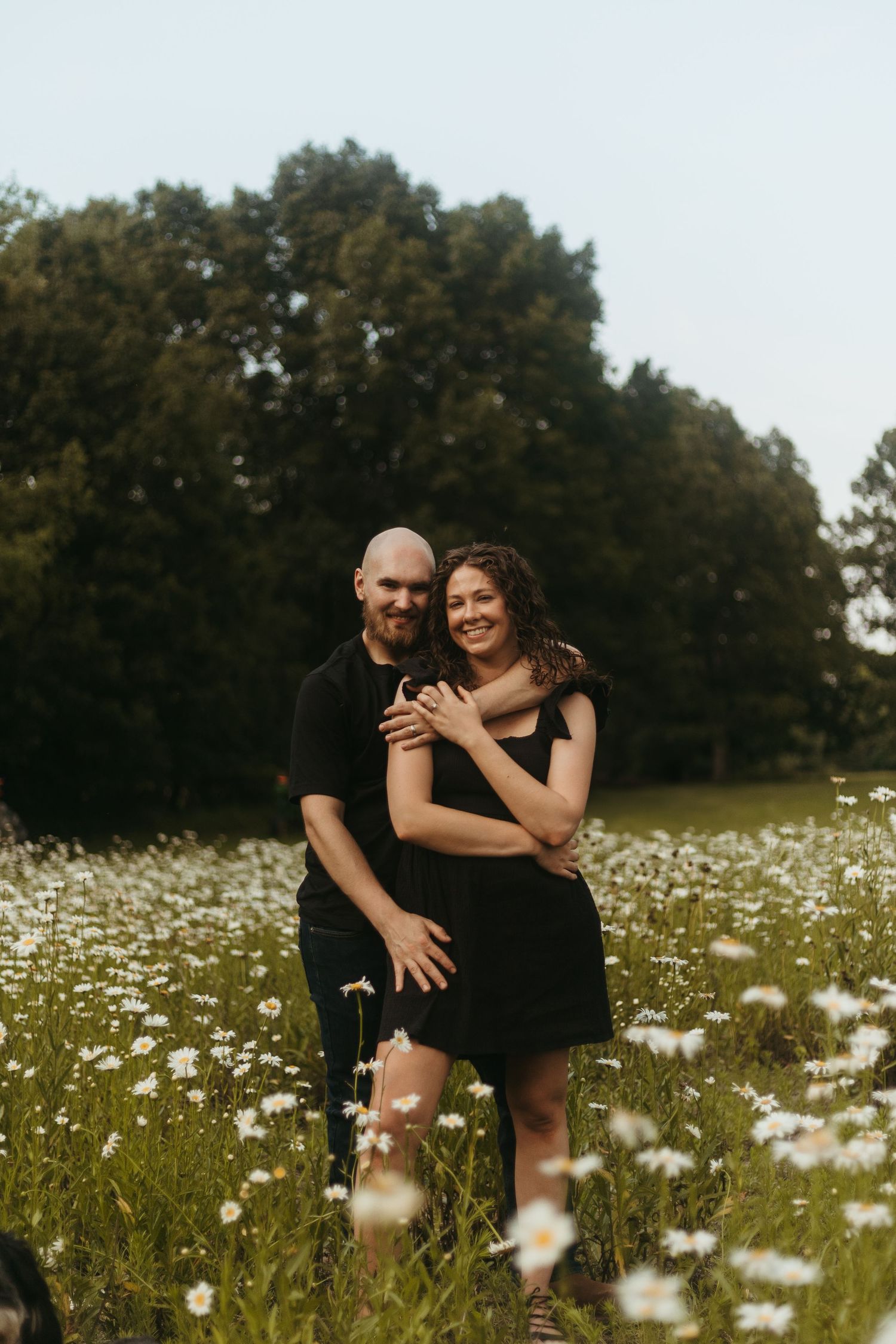 Couple embracing in a wildflower field during a family session with a Southeast Michigan photographer near Detroit.