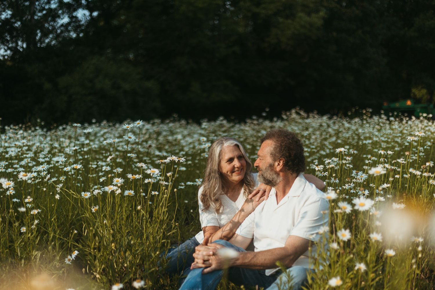 Couple embracing in a wildflower field during a family session with a Southeast Michigan photographer near Detroit.