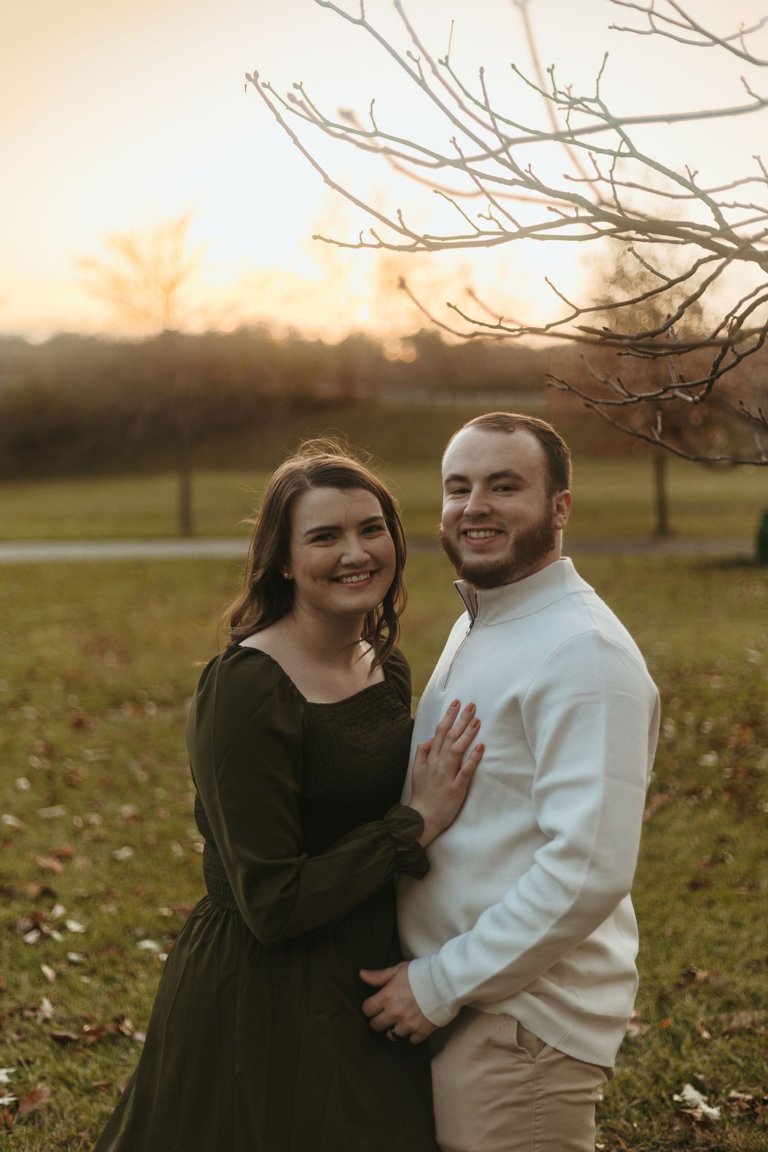 Golden hour couples portrait in Ann Arbor, Michigan featuring a couple standing together in a park with warm evening light