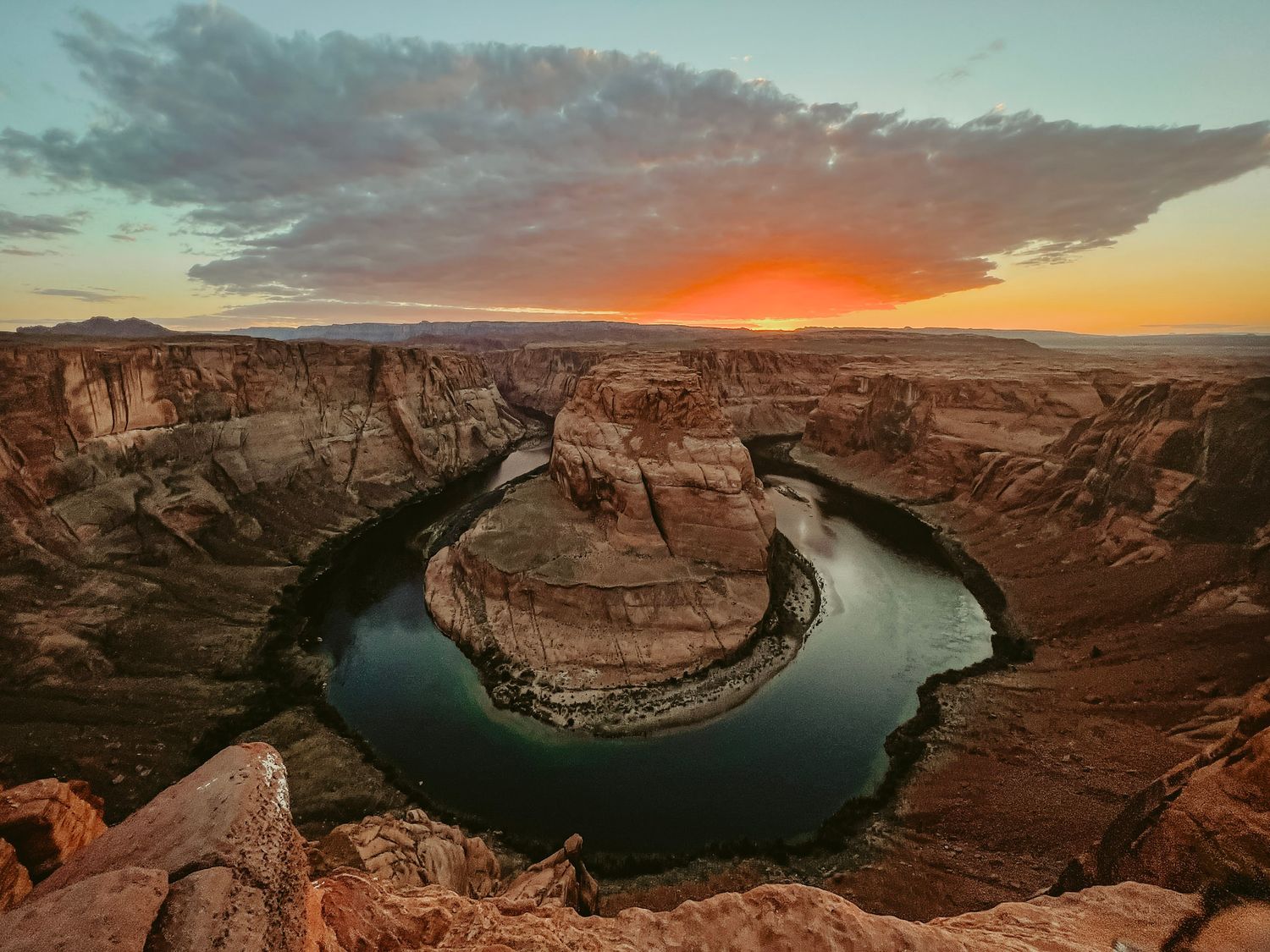 Sunset at Horseshoe Bend overlooking the Colorado River with warm light reflecting off red rock canyon walls