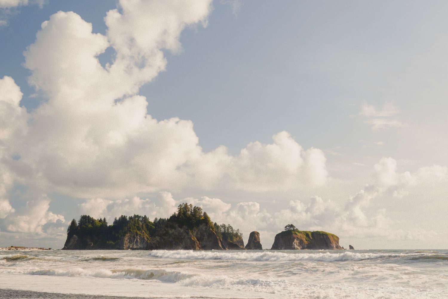 Waves crashing along the shoreline at Rialto Beach in Olympic National Park with sea stacks and soft coastal light