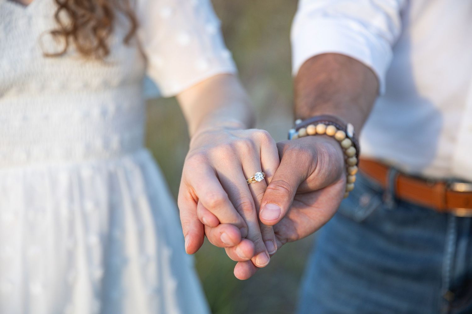Close-up of an engagement ring photographed on a sandy Lake Michigan beach in Indiana.
