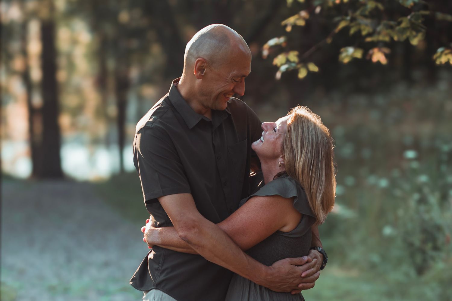 Outdoor couples portrait during an Oakland County family photo session featuring a couple standing together on a wooded trail