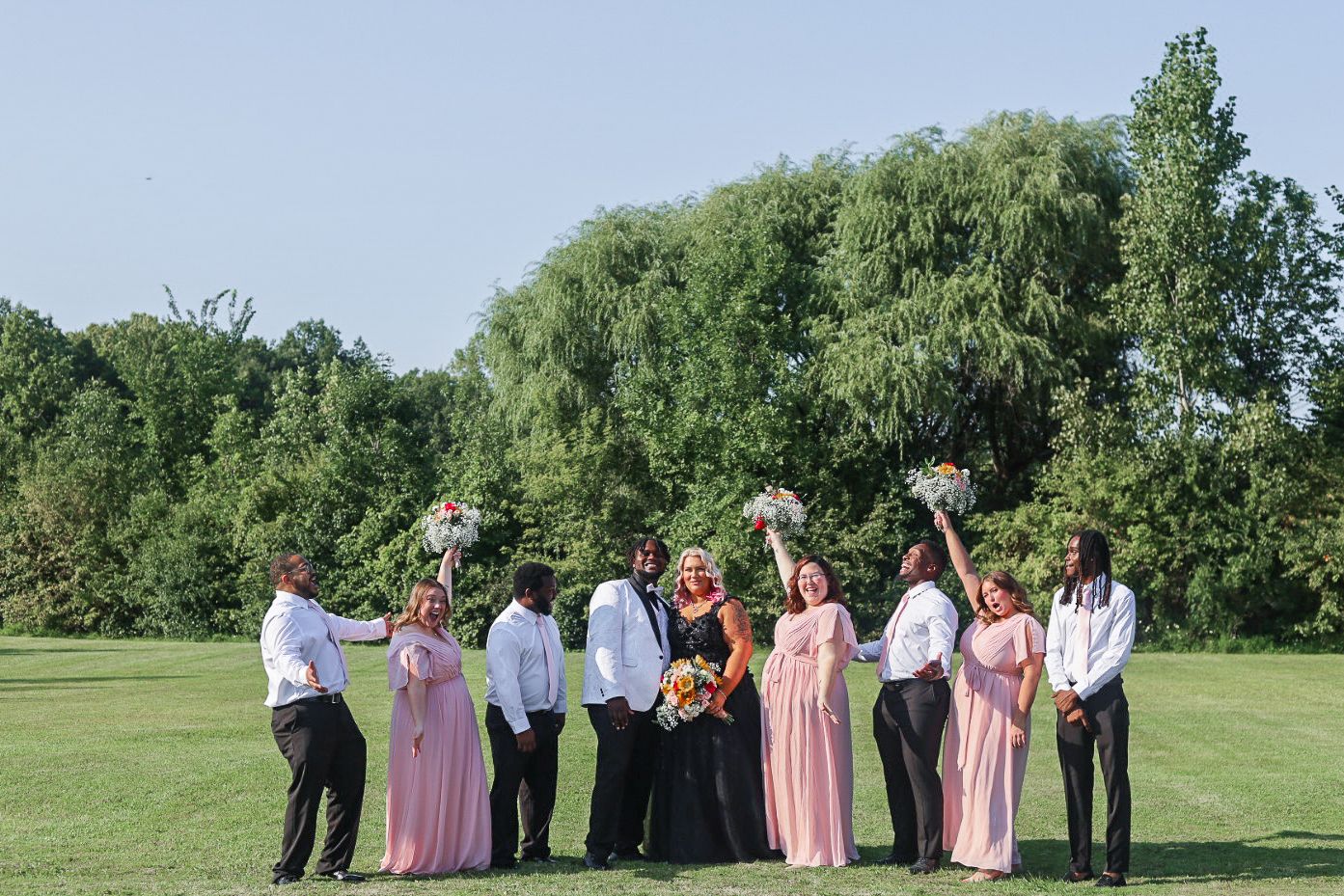 Flint Michigan wedding photography capturing a joyful bridal party portrait outdoors on the wedding day