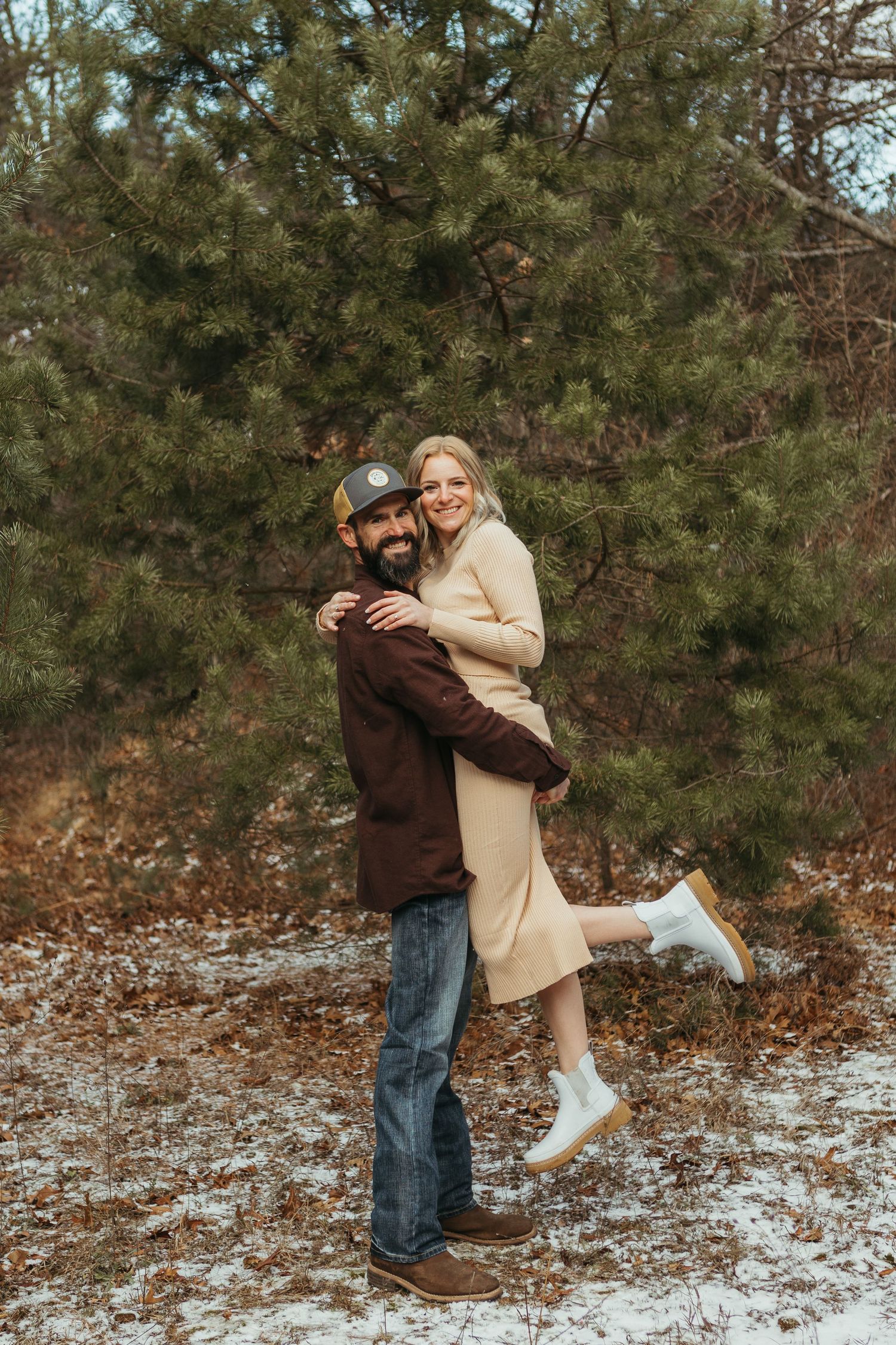 Winter engagement photo session in Lapeer, Michigan featuring a couple outdoors in a snowy natural setting
