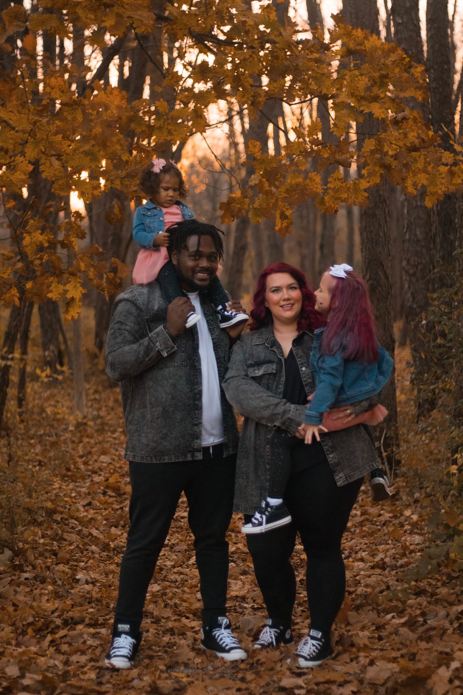 Fall family photo session in Genesee County, Michigan featuring a family together surrounded by autumn foliage