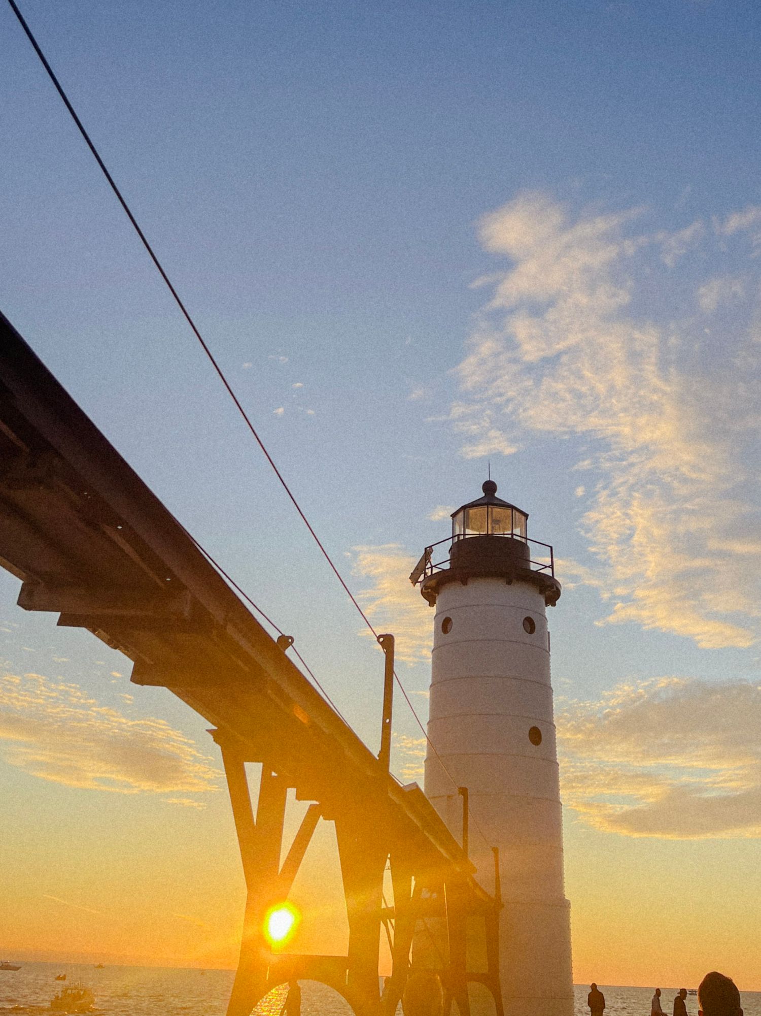 Sunset at the Manistee North Pierhead Lighthouse with warm golden light reflecting off Lake Michigan
