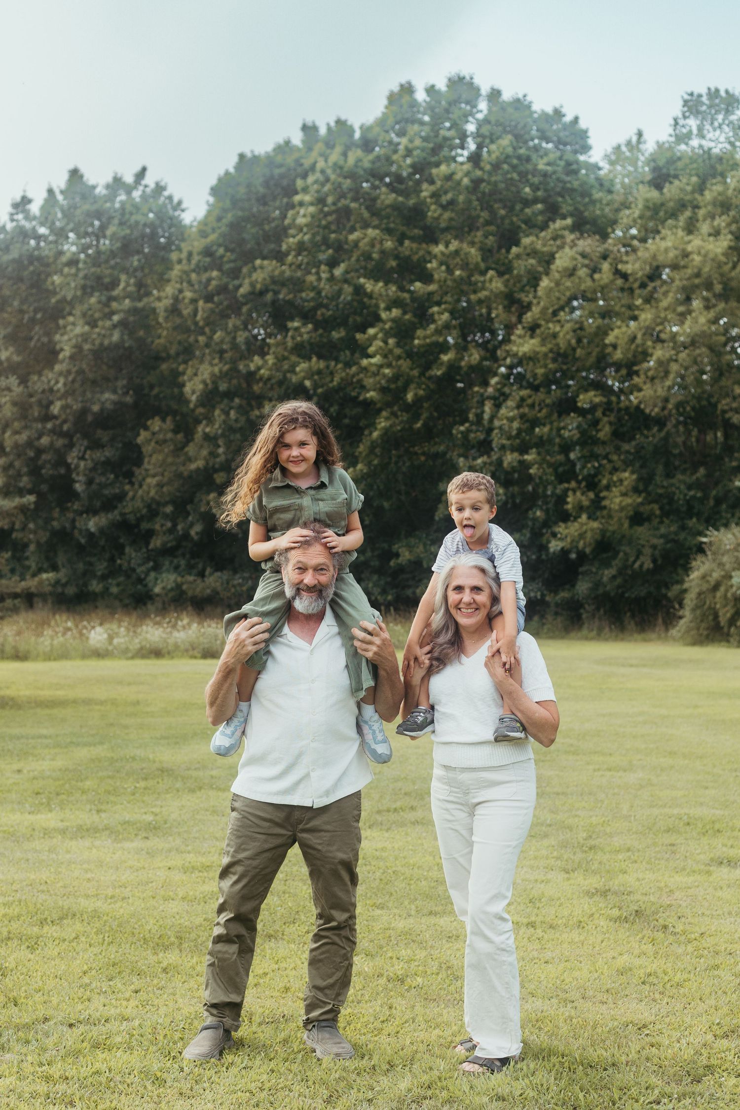 Candid family portrait from a Lapeer, Michigan photo session with parents, children, and grandparents outdoors
