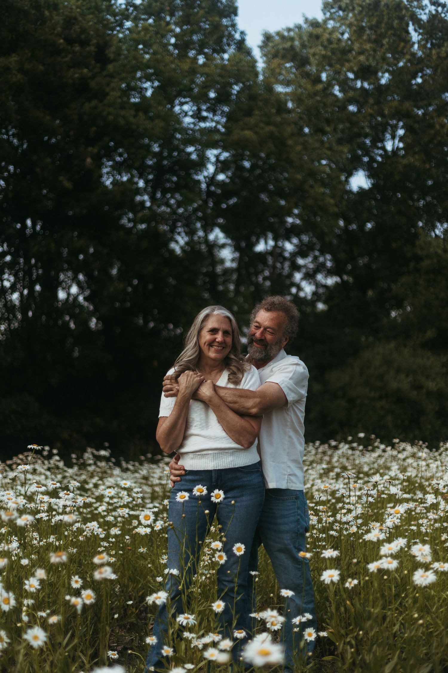 Couple embracing in a wildflower field during a family session with a Southeast Michigan photographer near Detroit.