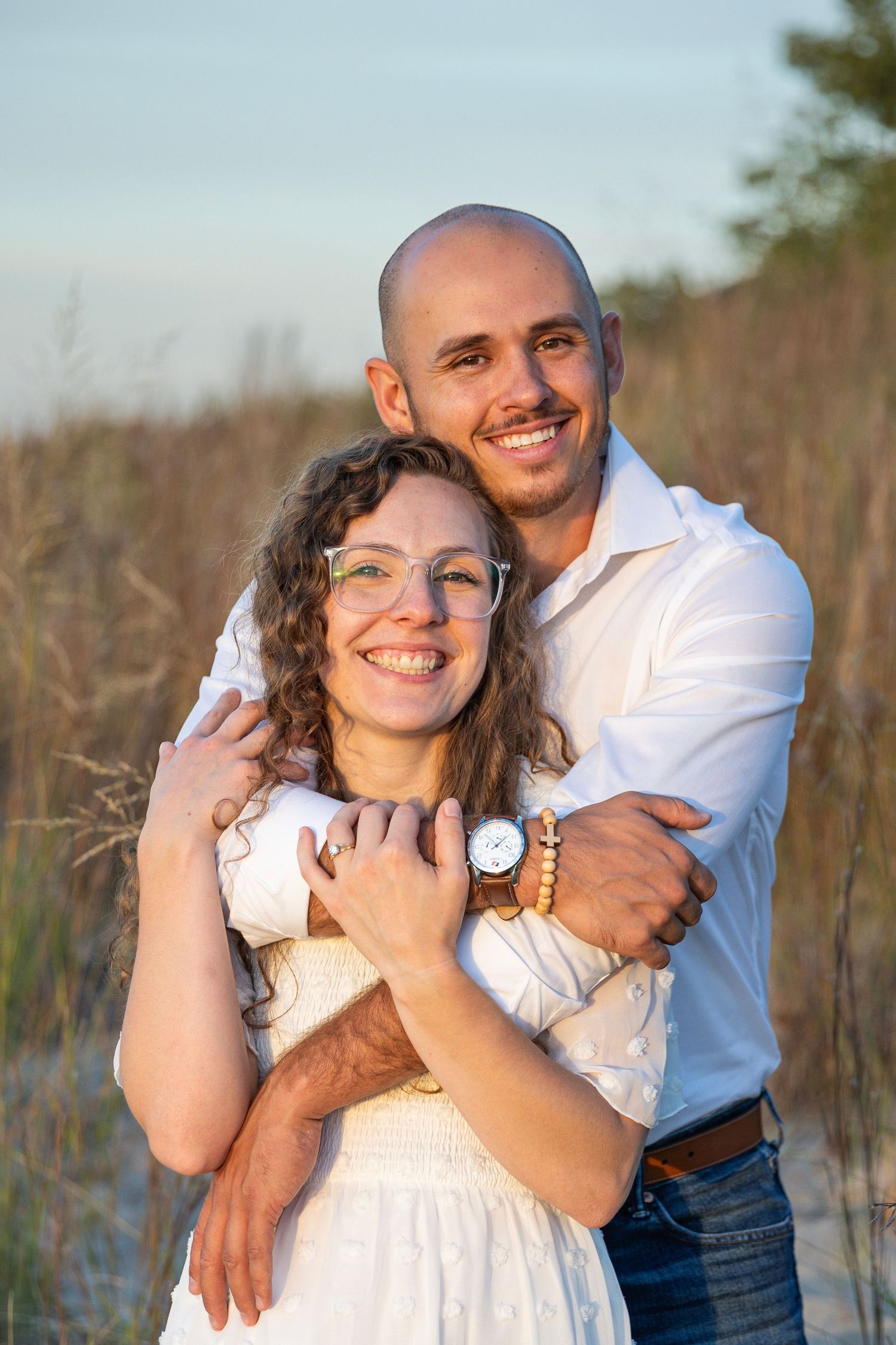 Candid engagement session at Lake Michigan with an engaged couple embracing outdoors