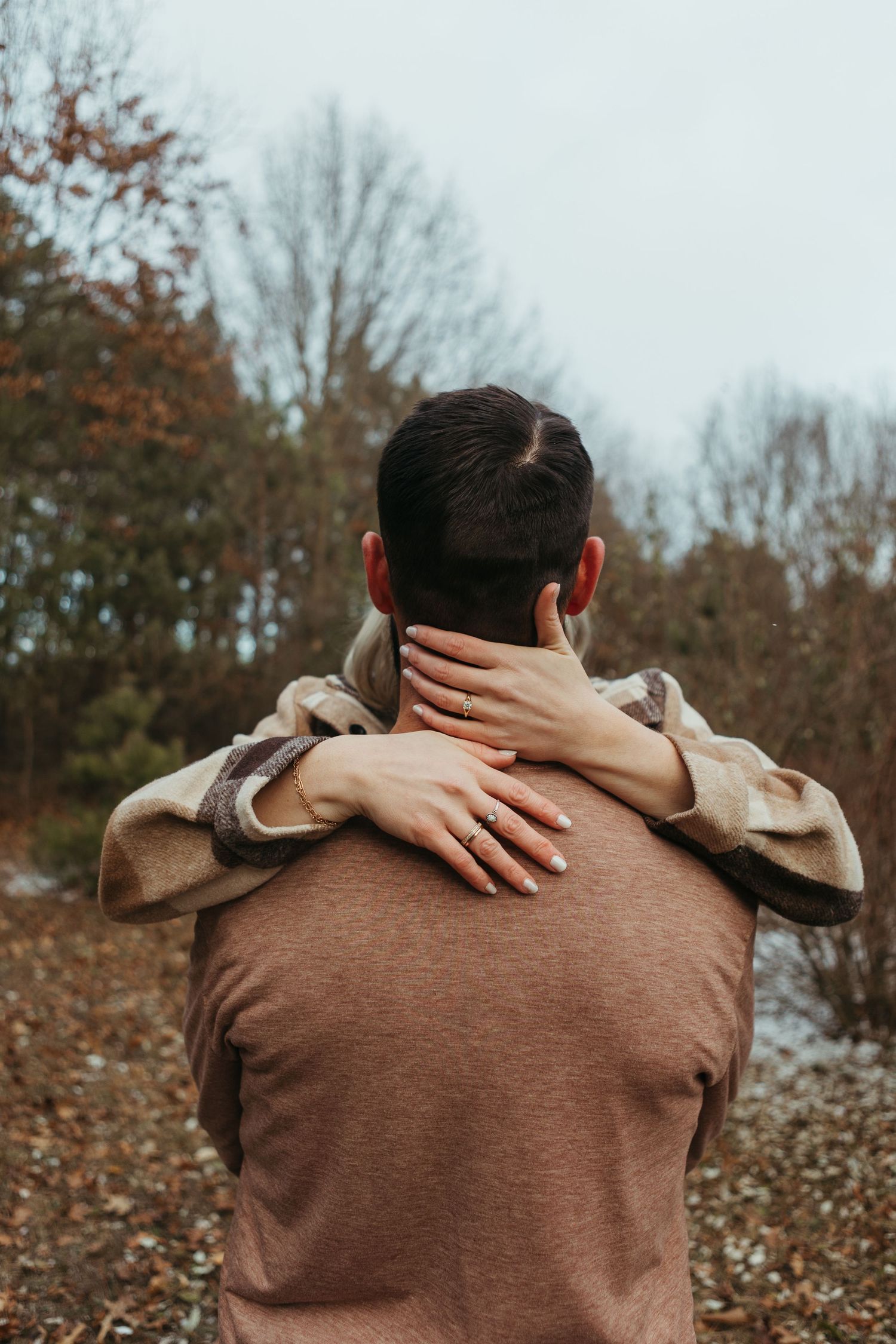 Winter engagement photo session in Lapeer, Michigan featuring a couple outdoors in a snowy natural setting