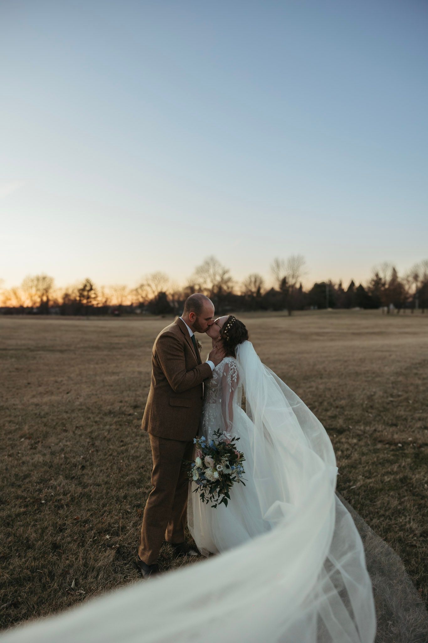 Bride and groom embracing during a March wedding in Indiana with soft early spring light.
