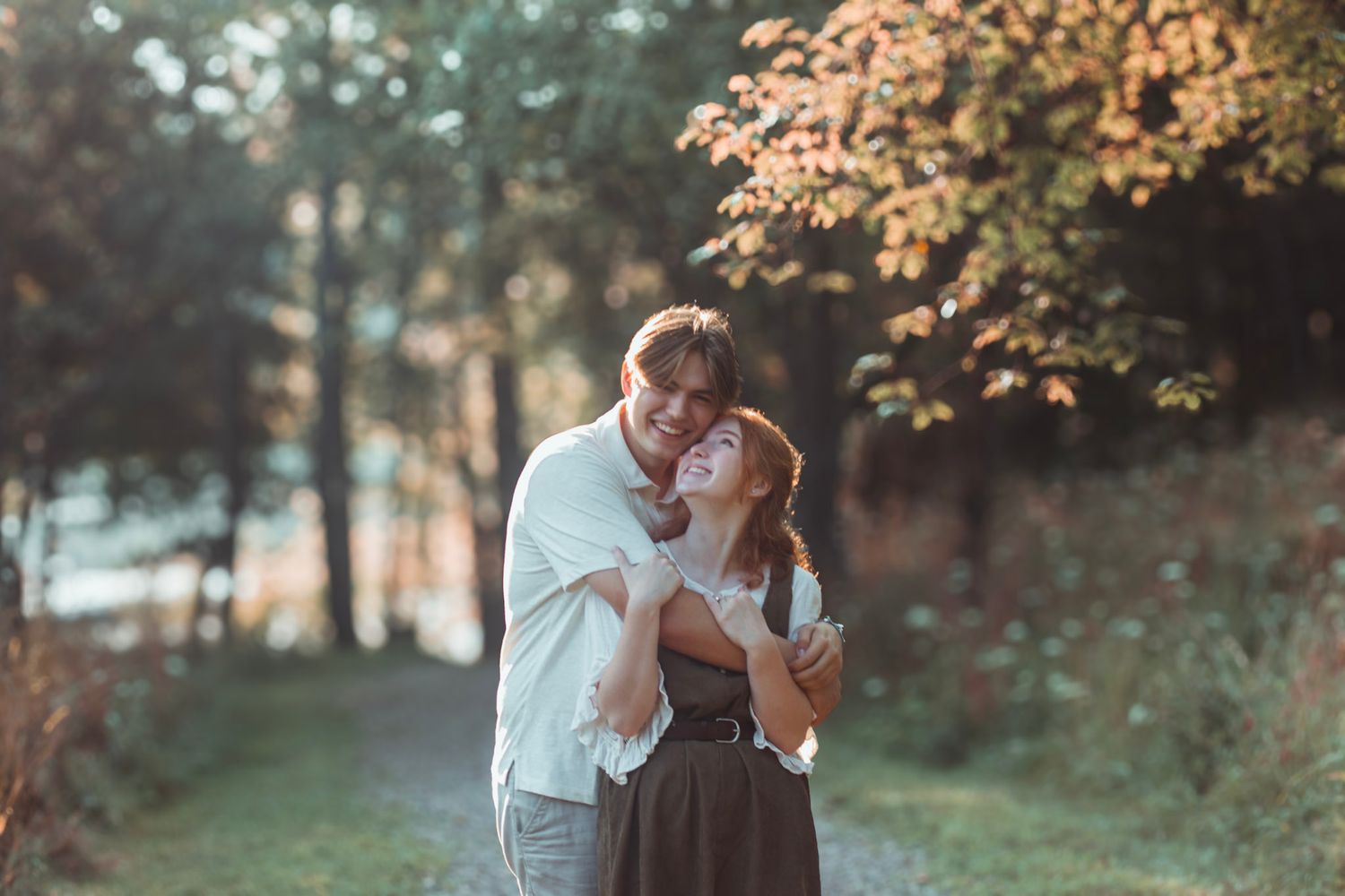 Outdoor couples portrait during an Oakland County family photo session featuring a couple standing together on a wooded trail