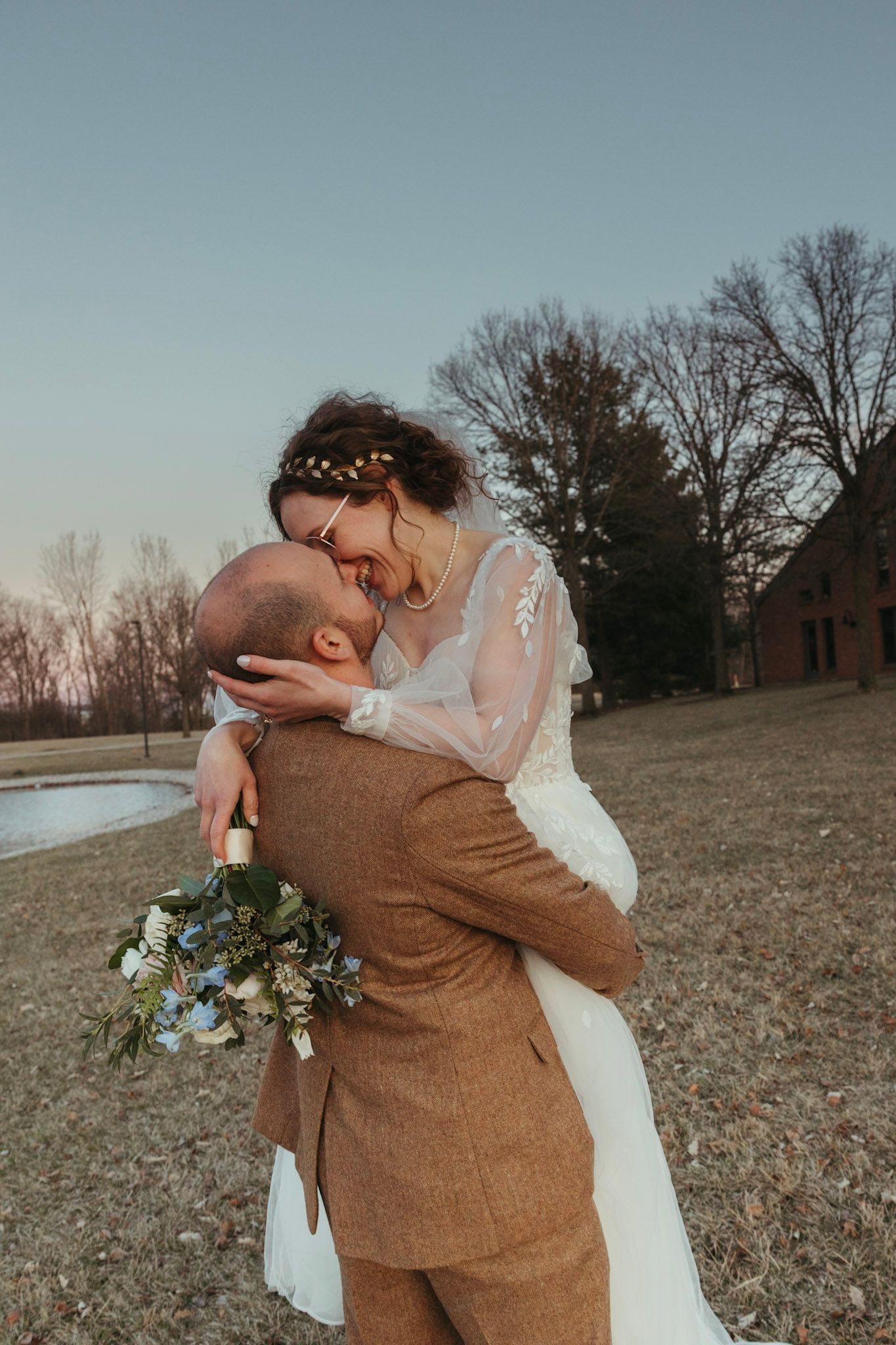 Bride and groom embracing during a March wedding in Indiana with soft early spring light.