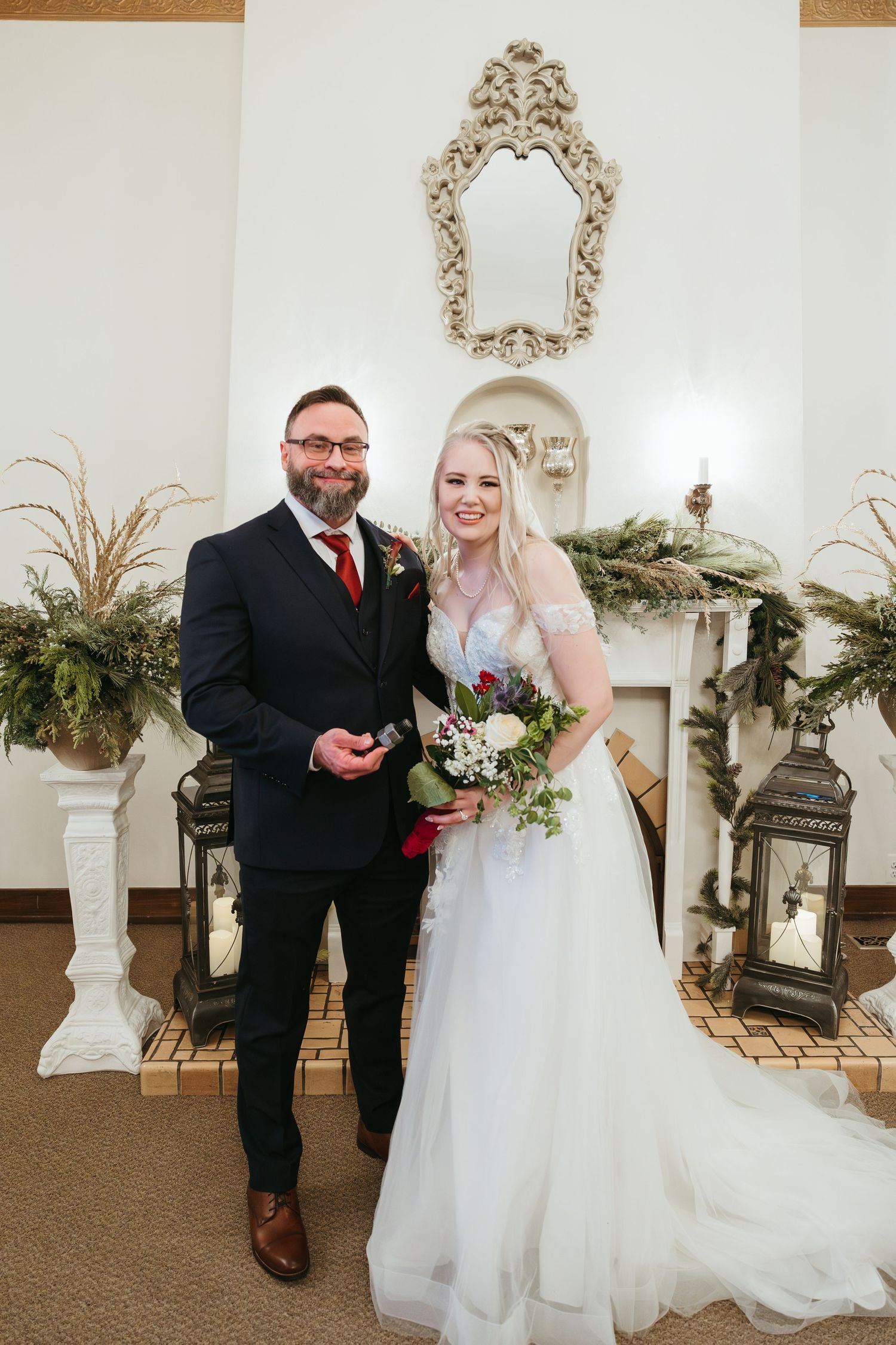 Bride and groom portrait at a winter wedding in Michigan standing together indoors beside a cozy fireplace