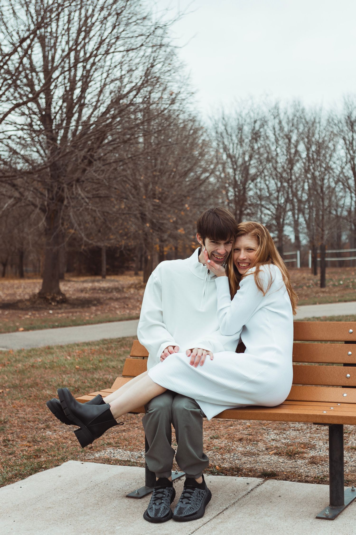 Candid engagement portrait in Oakland County, Michigan featuring a couple in a fall landscape