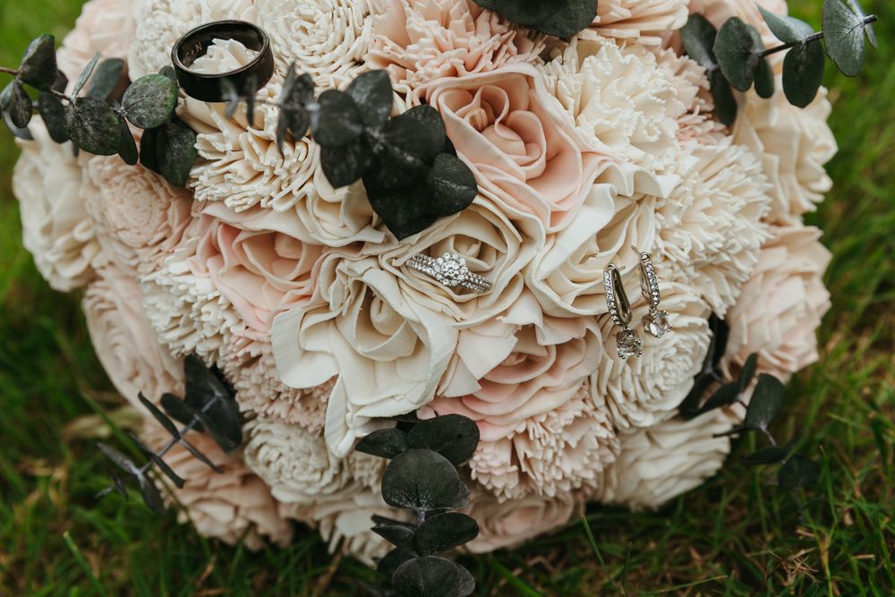 Wedding ring detail resting on a bridal bouquet during a Michigan wedding photographed in natural light