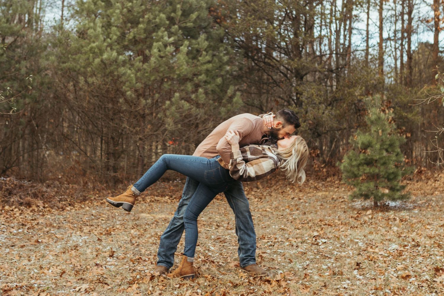 Winter engagement photo session in Lapeer, Michigan featuring a couple outdoors in a snowy natural setting