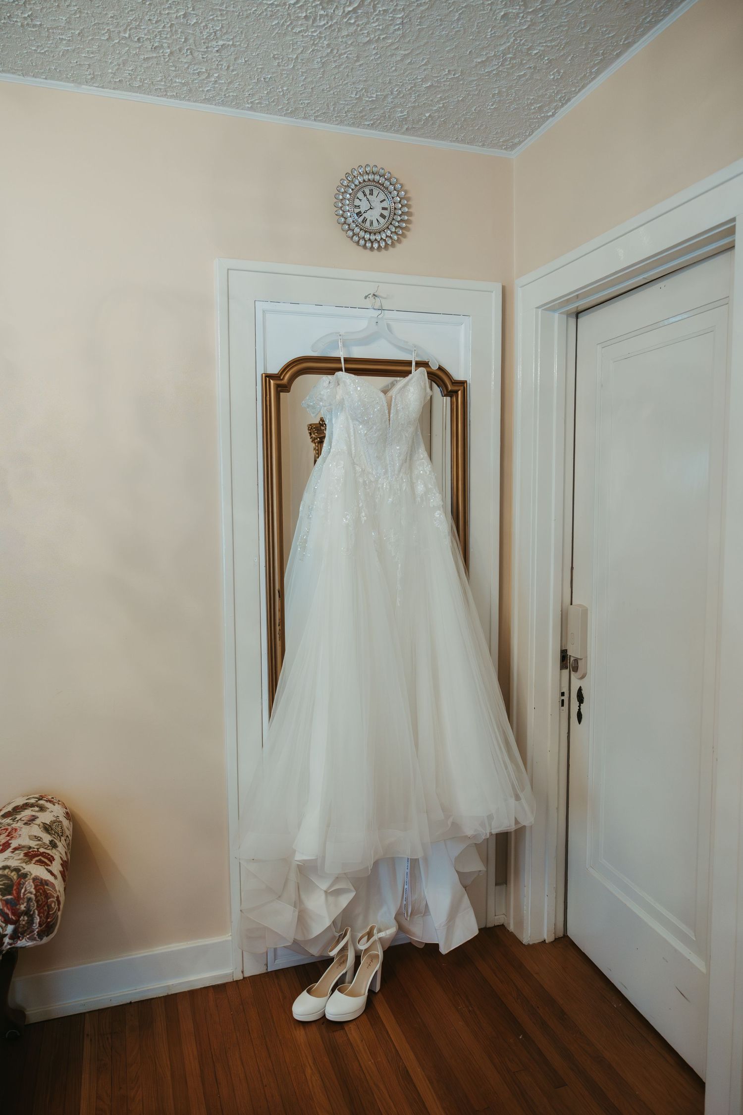 Wedding dress hanging inside a bridal getting ready space during a Michigan wedding in soft natural light