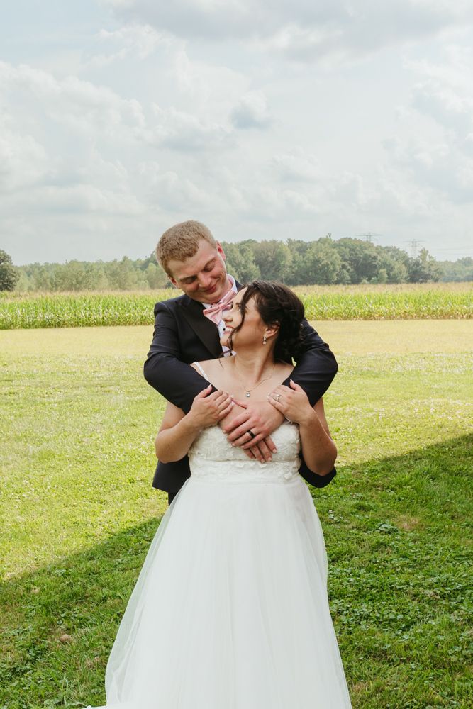 Emotional bride and groom portrait during an August outdoor wedding in New Boston, Michigan in a grassy field