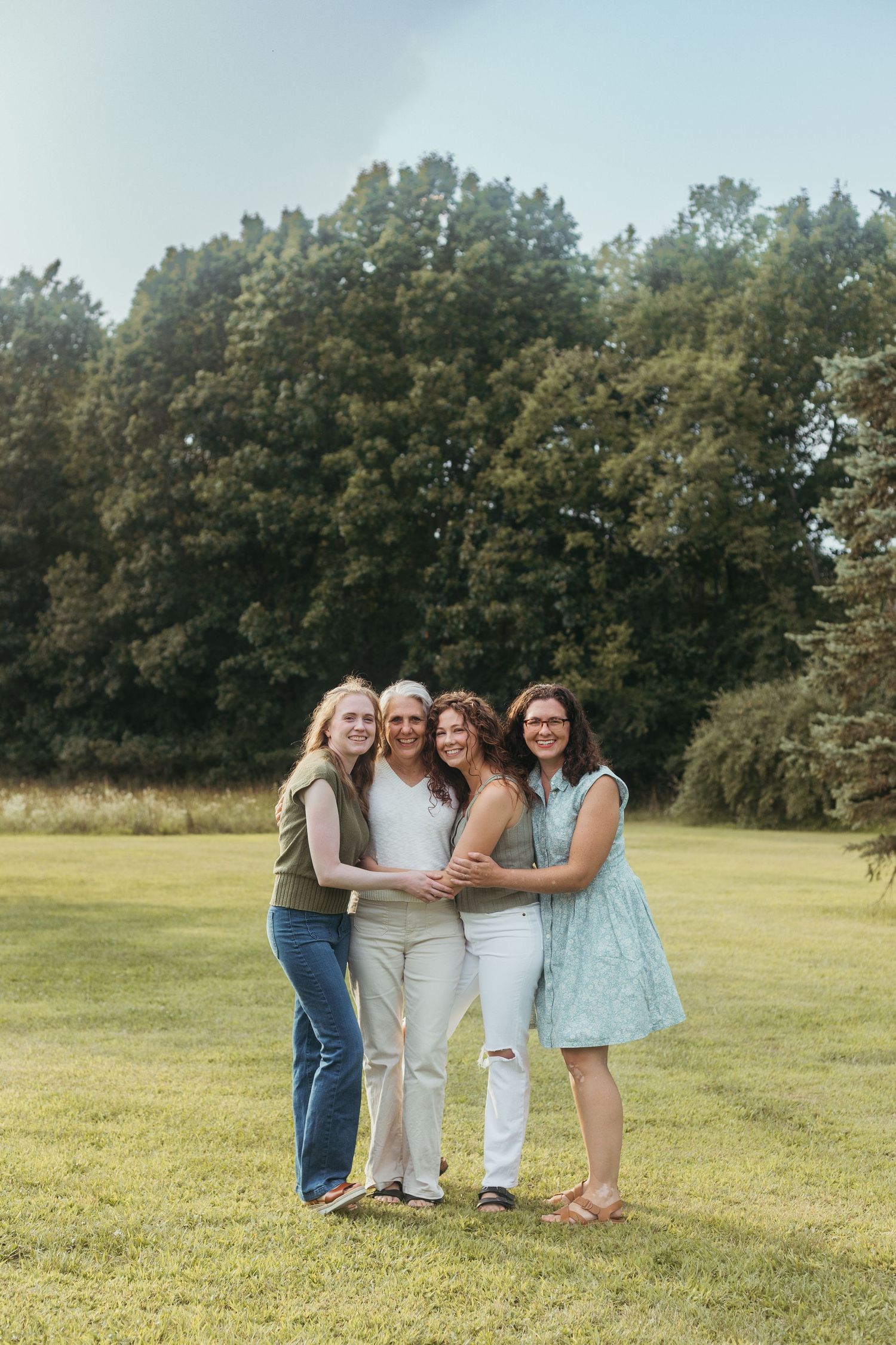 Lifestyle family photography session in Lapeer, Michigan with a large family gathered in a scenic outdoor setting