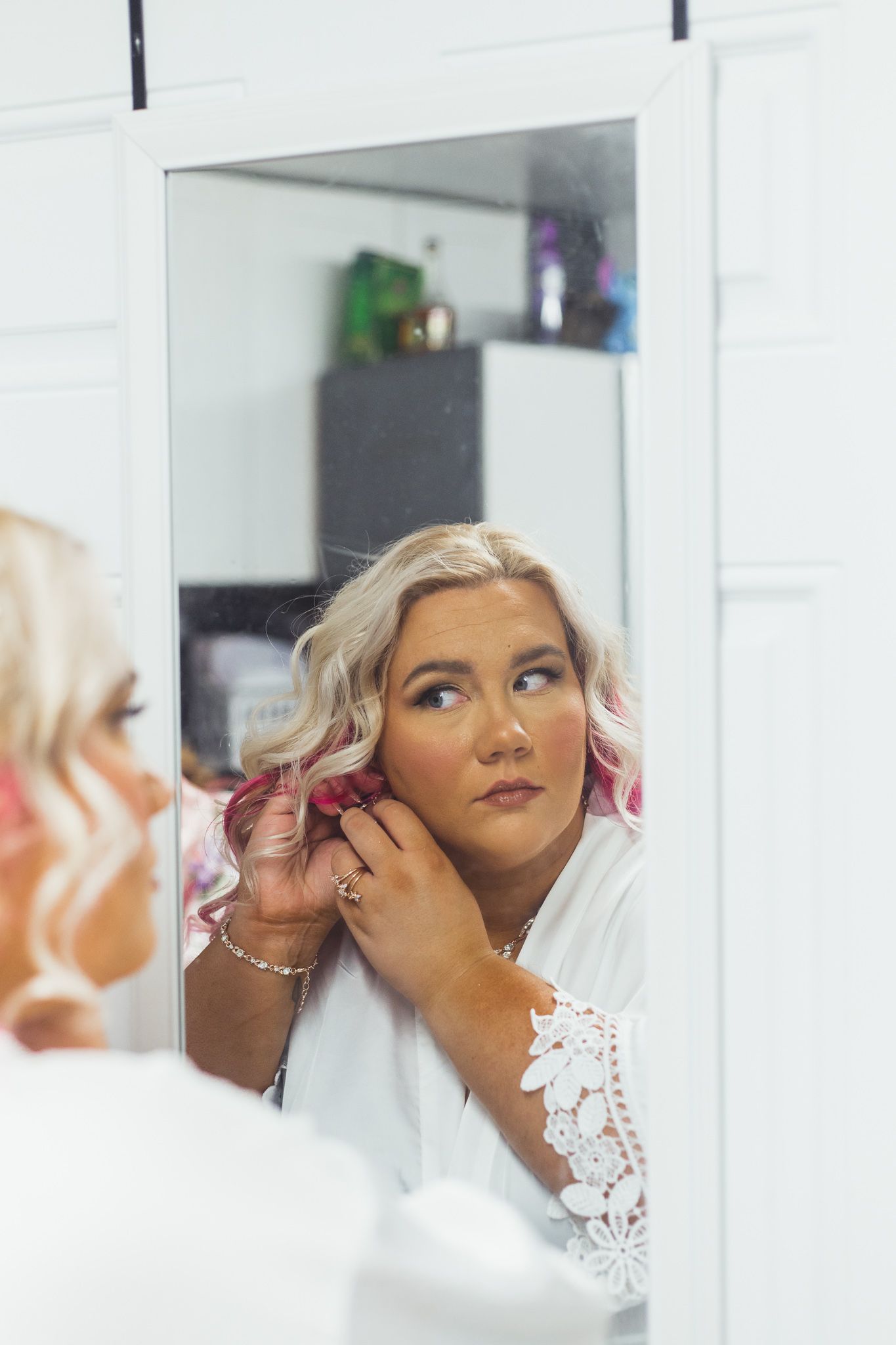 Bride putting on her jewelry during a Flint, Michigan wedding while getting ready for the ceremony