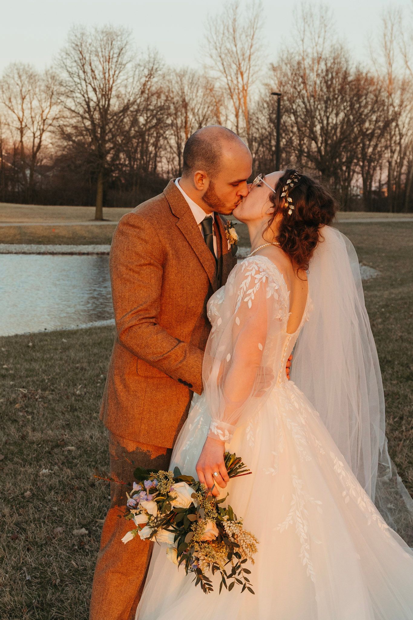 Bride and groom embracing during a March wedding in Indiana with soft early spring light.